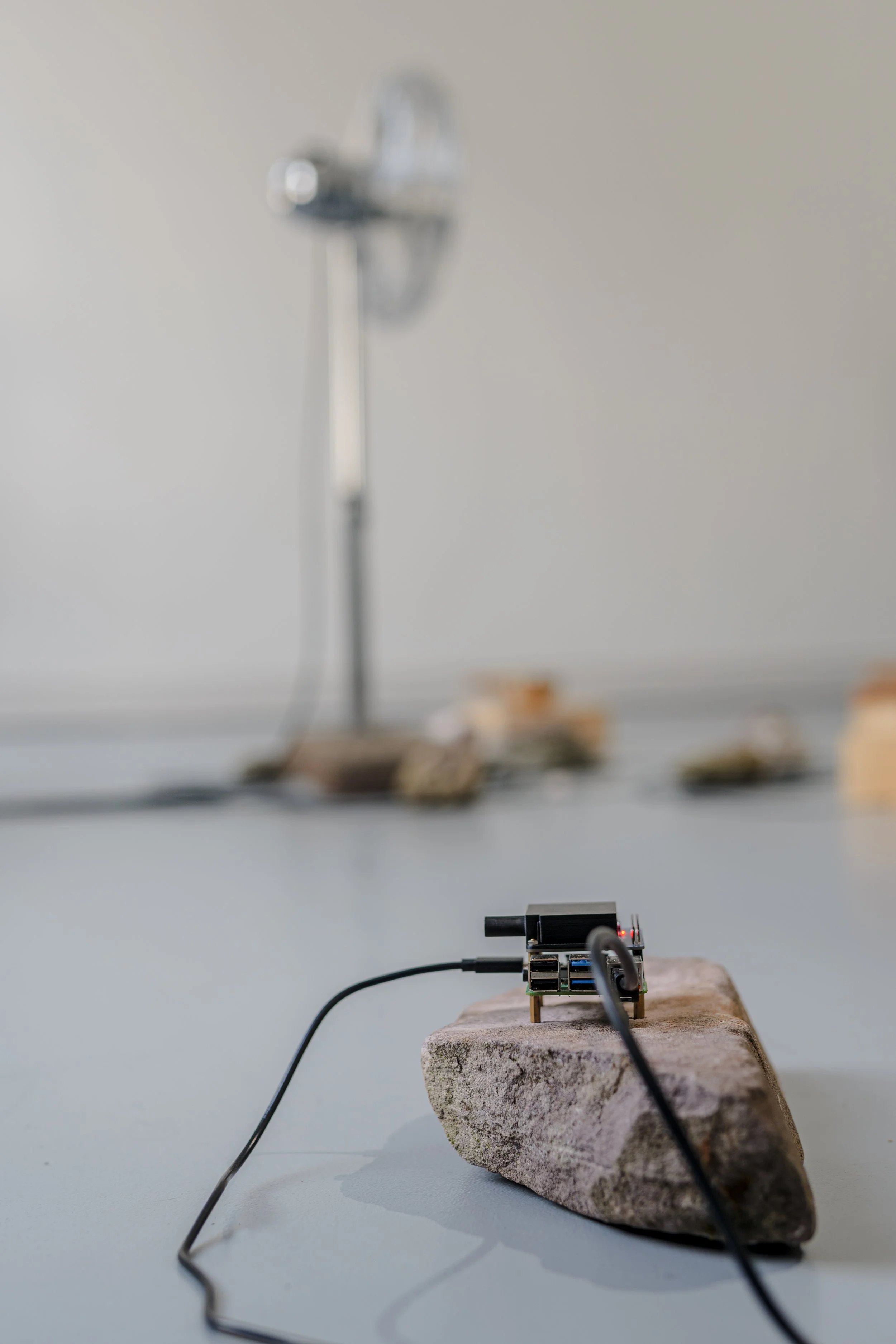  Where Does the Body End? , 2025, air quality sensor, singing bowls, chrome-plated pedestal fan, wood, carved stone, 3D-printed components, five-channel sound, custom software, Raspberry Pi microcomputers, Arduino microcontrollers, motors, circuitry,