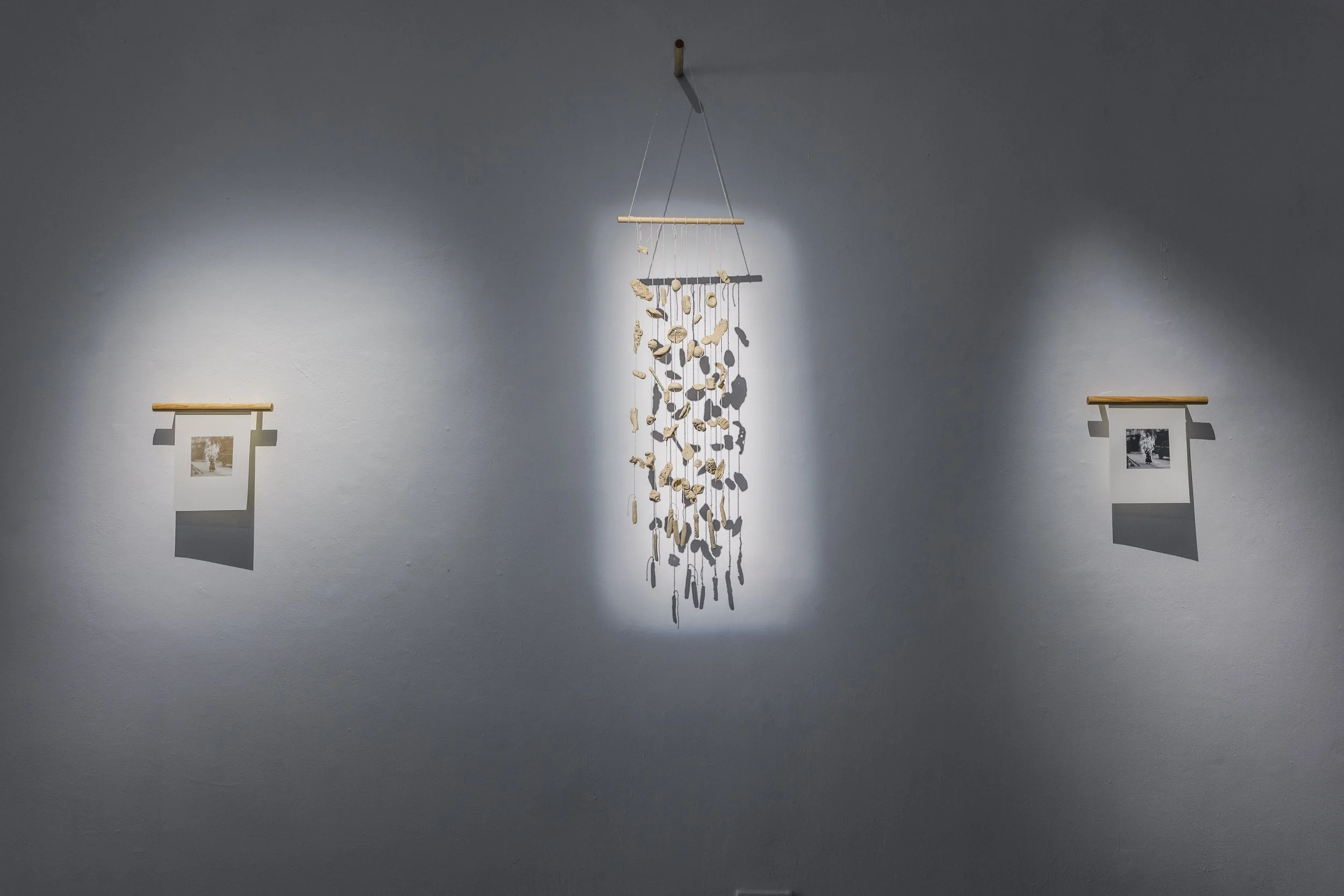  Together in the Atmosphere 1 , 2025, screenprint with gold ink on ivory linen paper;  Together in the Atmosphere 3 , 2025 ceramics, string, wood;  Together in the Atmosphere 2 , 2025, screenprint with black ink on ivory linen paper. Installation vie