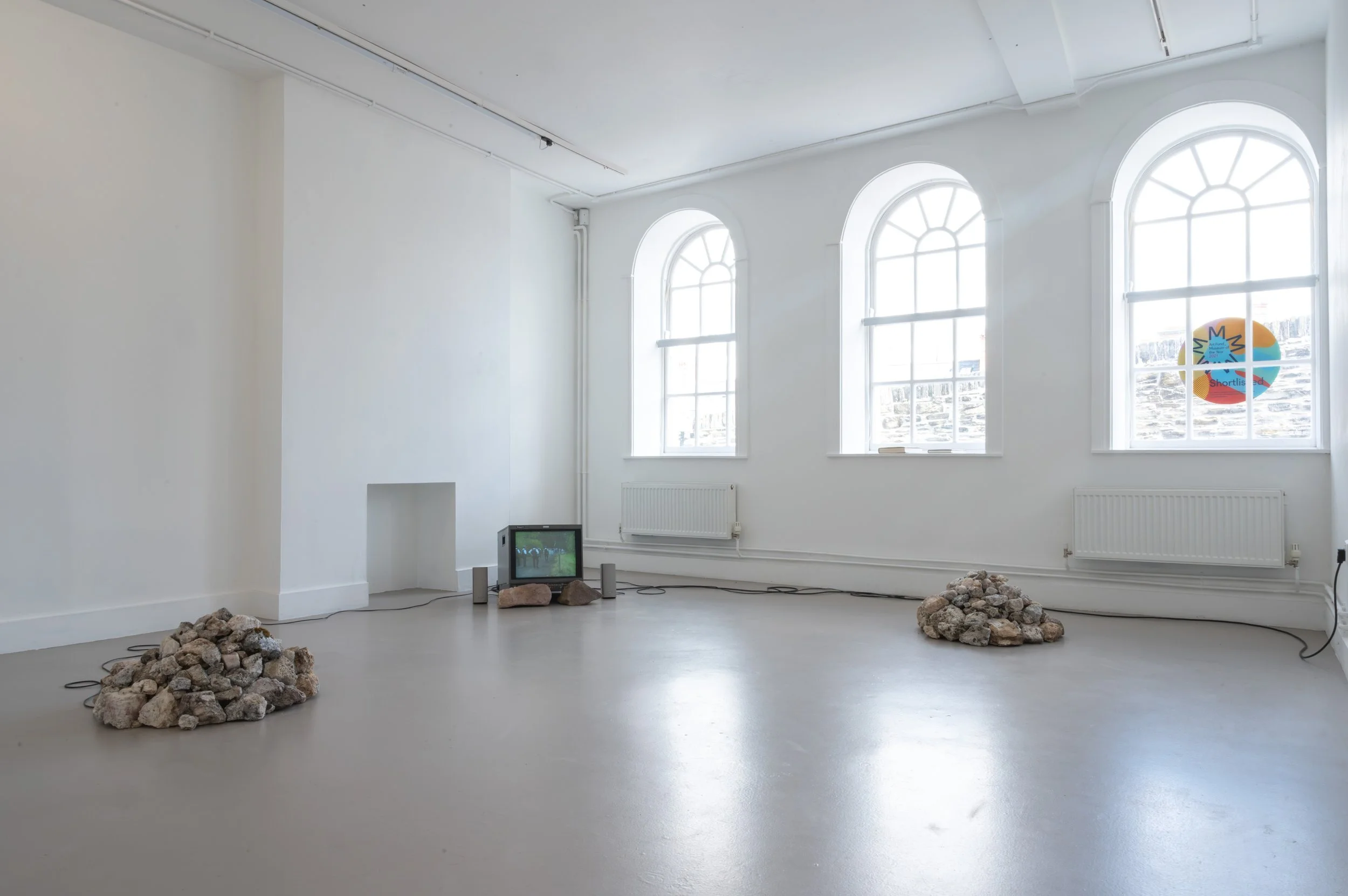 Vinny Cunningham,  Moving Border Bollards , 1994, HD, colour, stereo sound. Duration: 4 min 38 sec (looped), with 
Christopher Steenson,  The Movers , 2026, four-channel spatial sound, voices of collaborators, hand-collected rock quartz, speakers, st