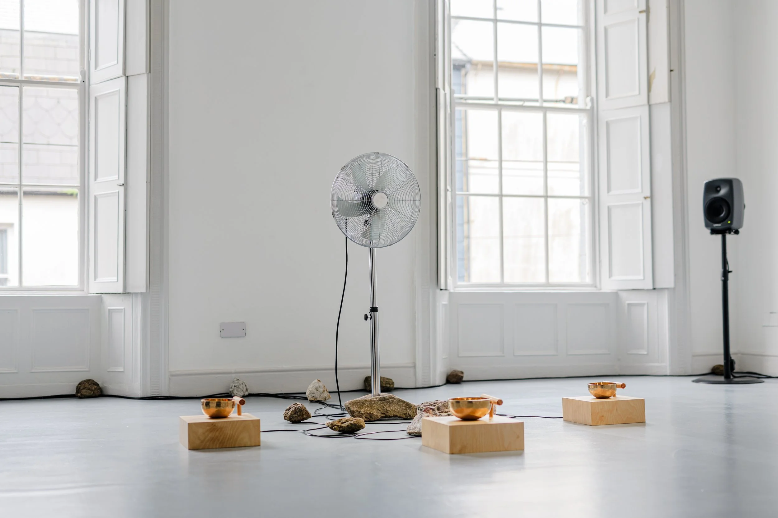  Where Does the Body End? , 2025, air quality sensor, singing bowls, chrome-plated pedestal fan, wood, carved stone, 3D-printed components, five-channel sound, custom software, Raspberry Pi microcomputers, Arduino microcontrollers, motors, circuitry,
