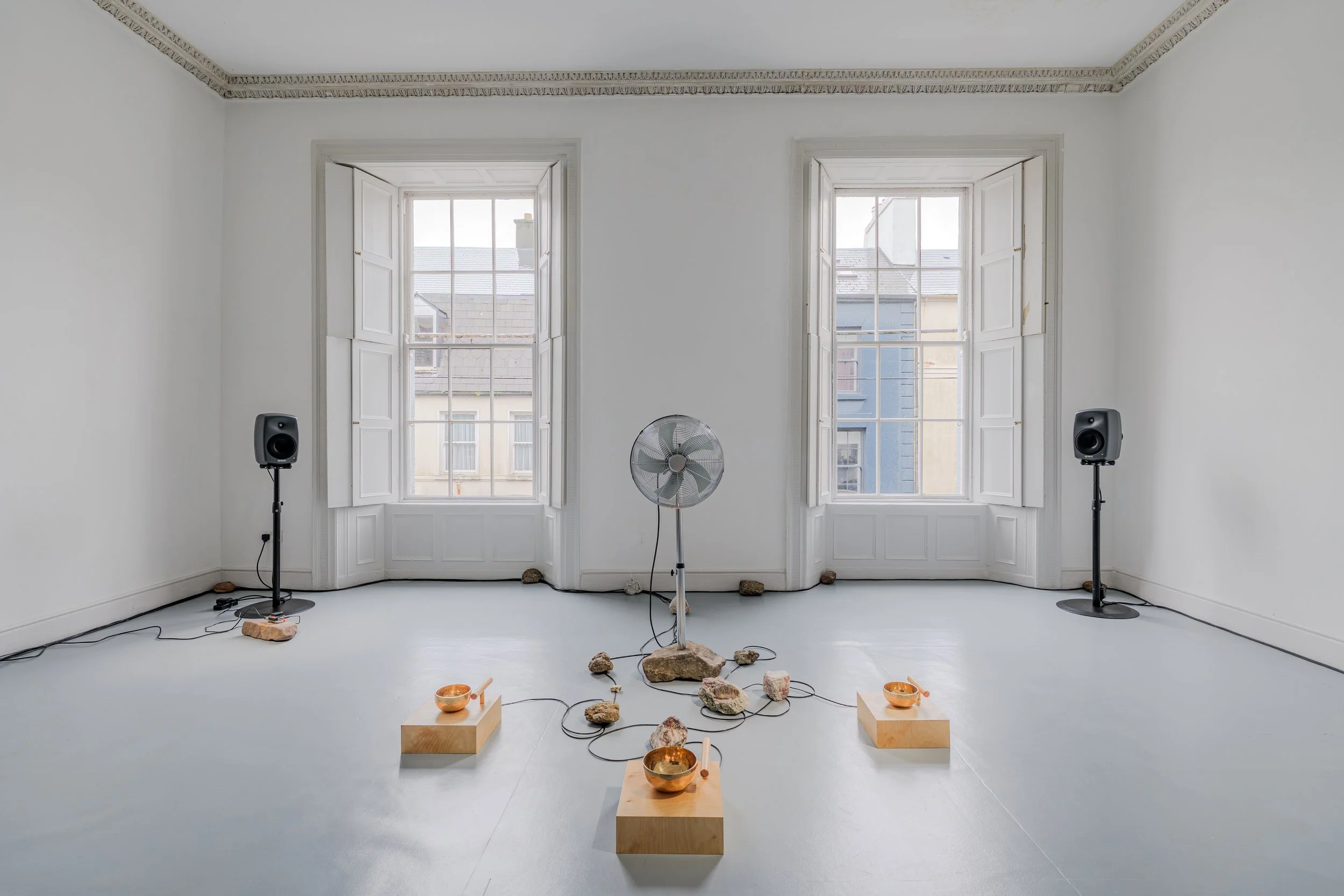  Where Does the Body End? , 2025, air quality sensor, singing bowls, chrome-plated pedestal fan, wood, carved stone, 3D-printed components, five-channel sound, custom software, Raspberry Pi microcomputers, Arduino microcontrollers, motors, circuitry,