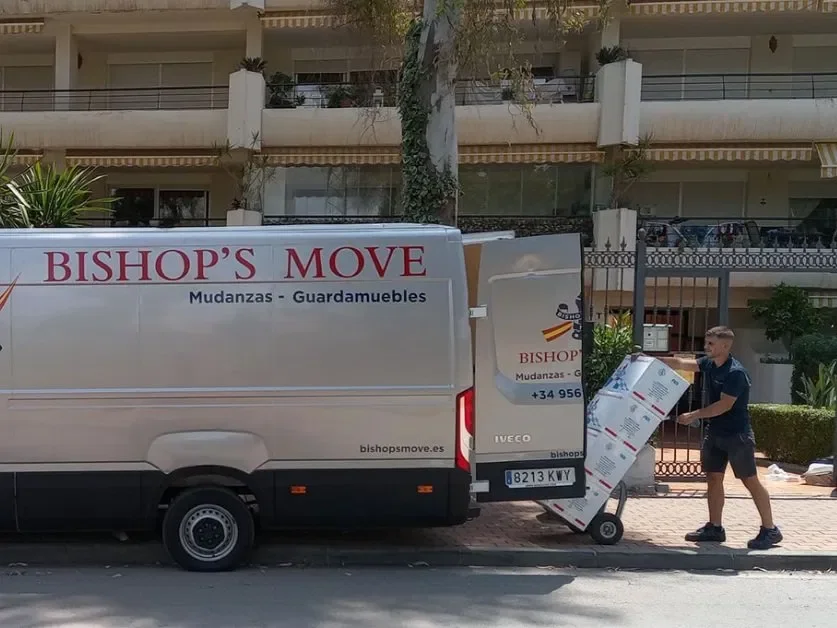 Bishop's Move Spain team member loads professionally packed boxes onto a branded removals van.