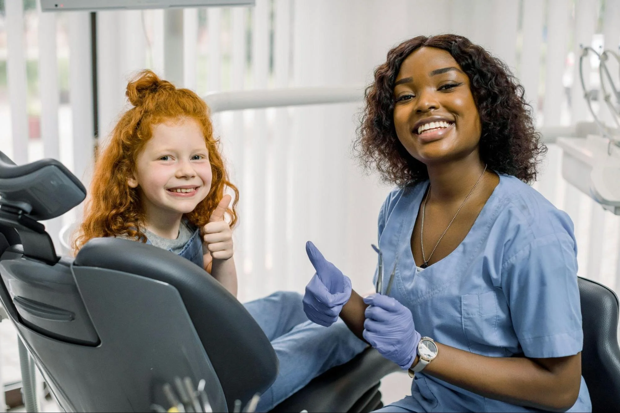 Little girl gives thumbs up at the dentist office