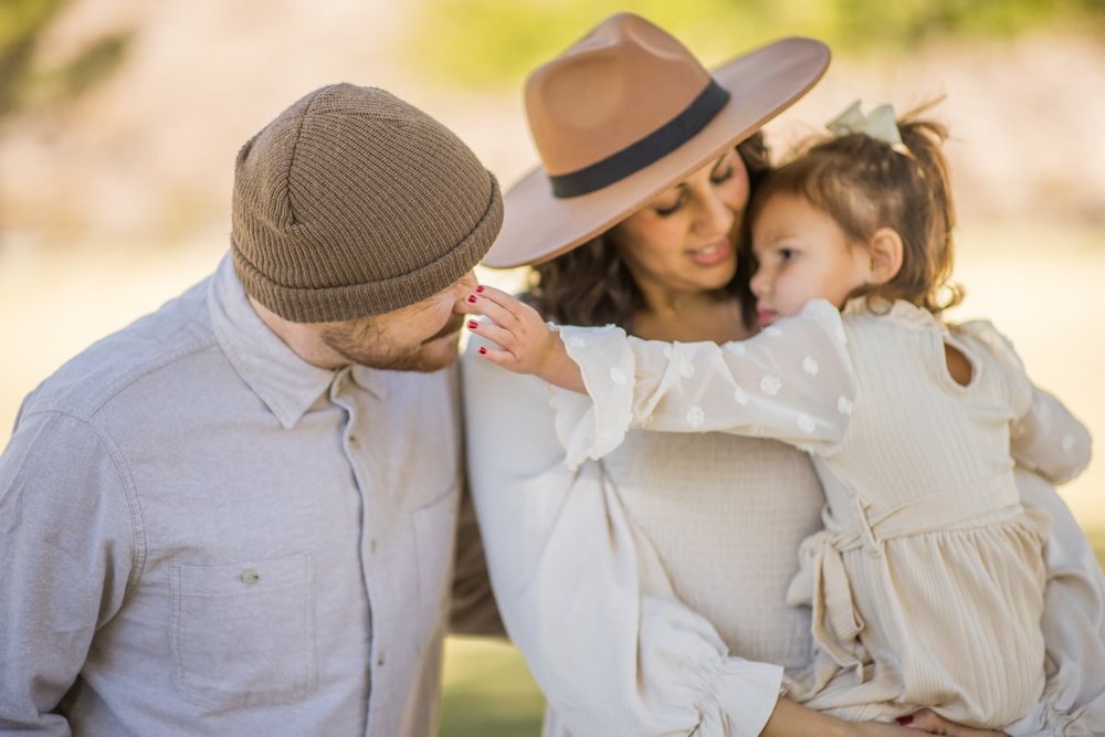 Parents holding their daughter close during a Las Vegas family photography session