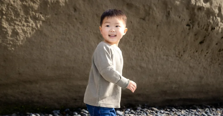 Young boy laughing against the sandstone bluff during a Carlsbad kids photo session
