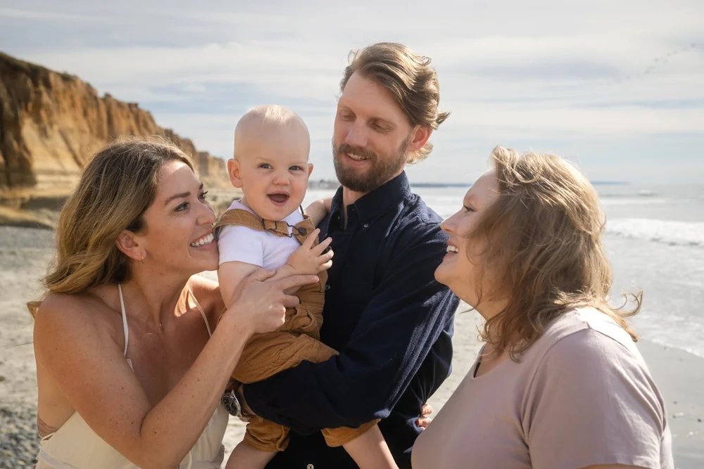 Multi-generational family portrait with a smiling baby outdoors