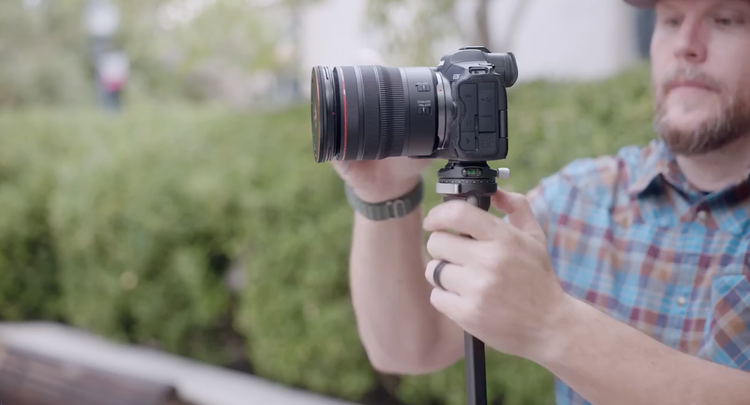 Joseph mounting a camera on a tripod outdoors
