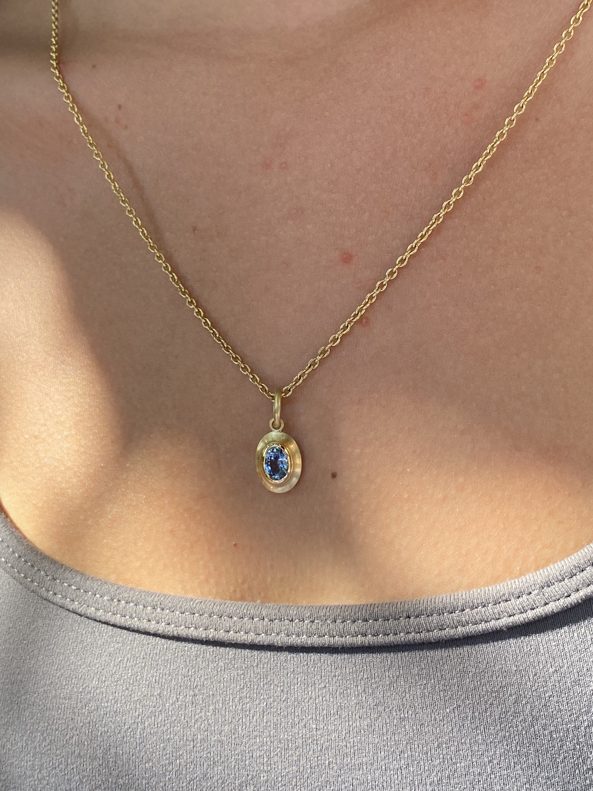 montana sapphire pendant worn by modelset in 18k fairmined gold made in USA.jpeg