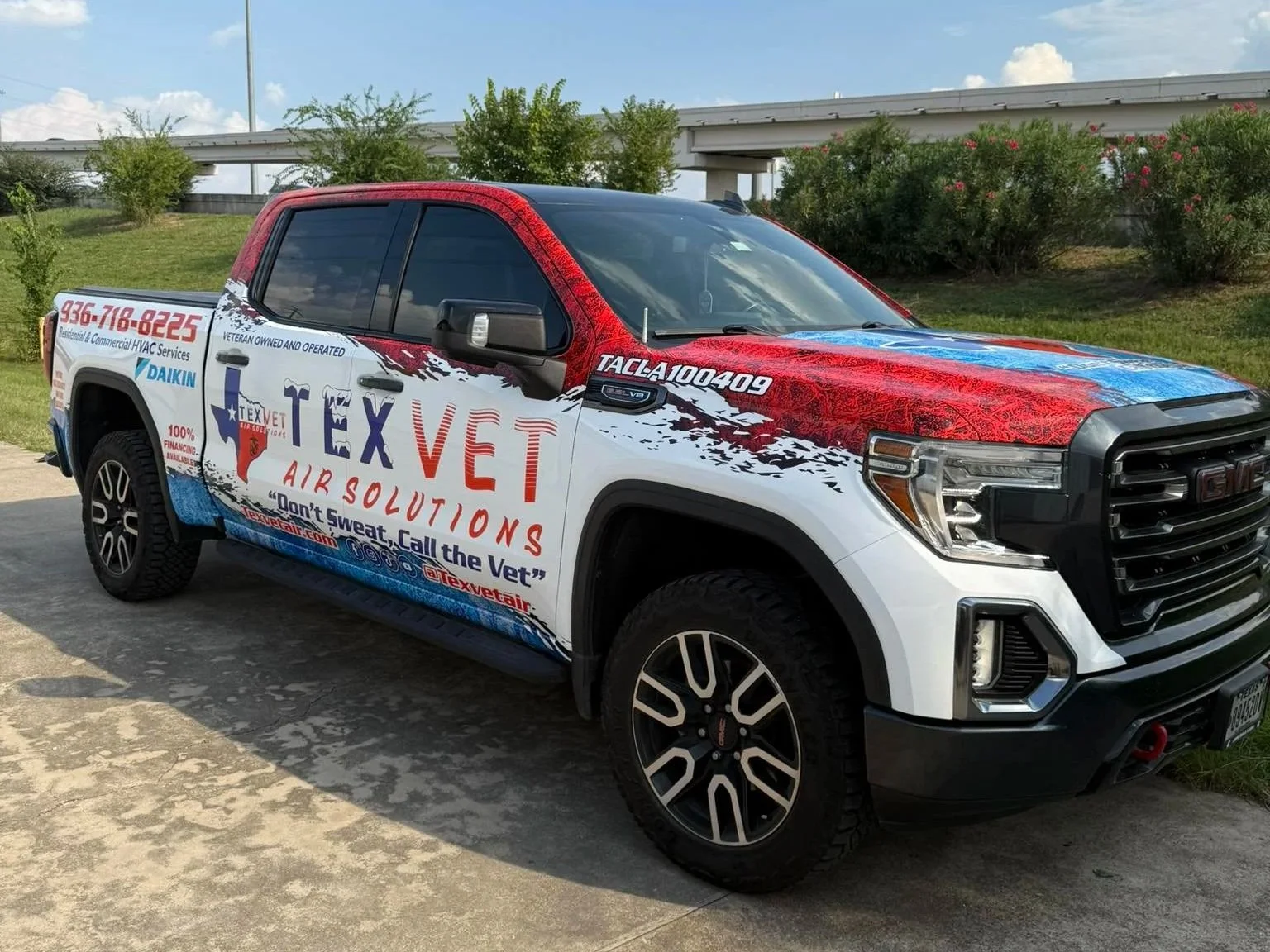 A pickup truck decorated with Tex Vet Air Solutions branding, featuring red, white, and blue graphics, logos, and contact information.