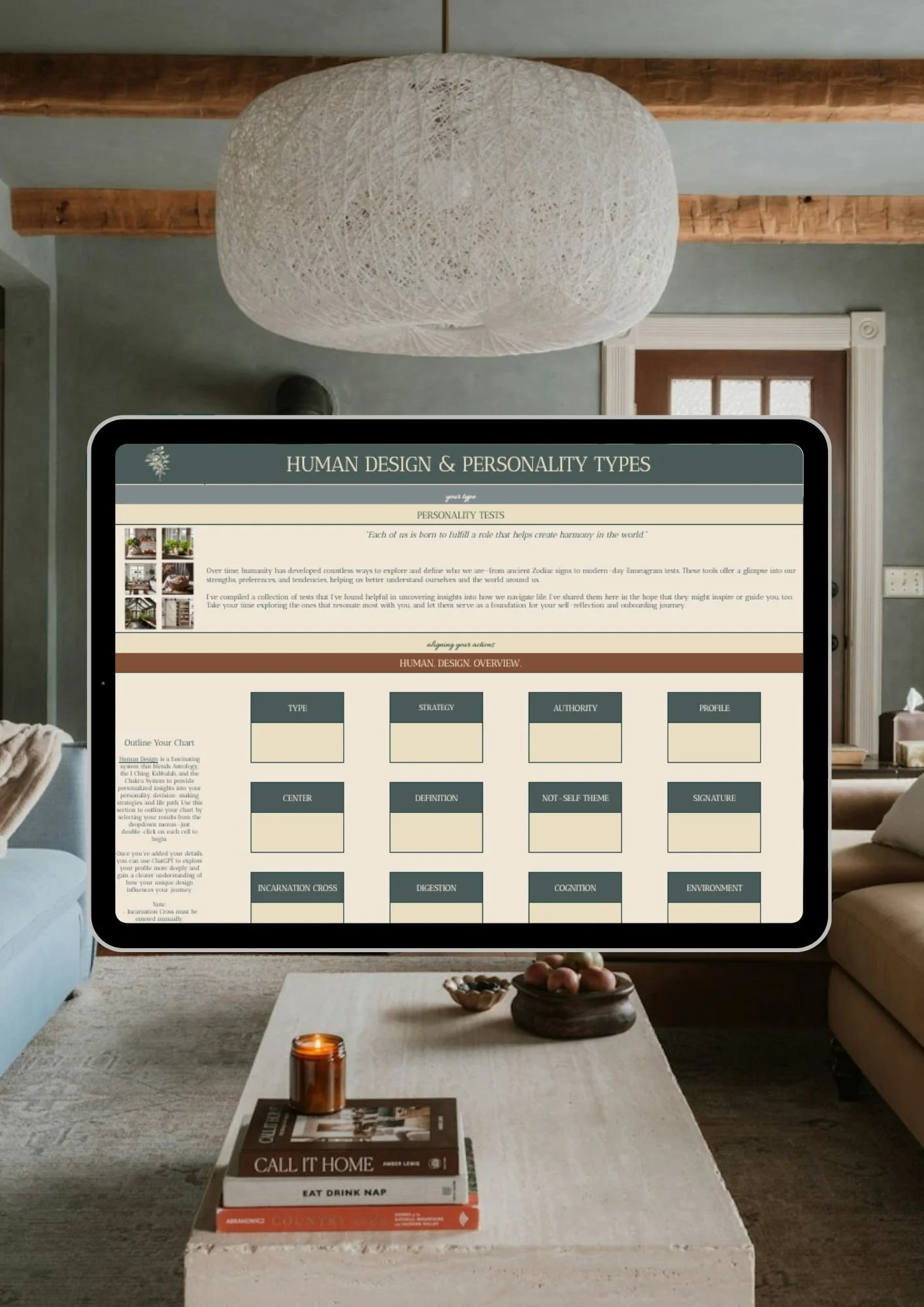 An iPad displaying a Human Design & Personality Types chart in a cozy living room with a large pendant light, wooden beams, and a coffee table with books and a small candle.