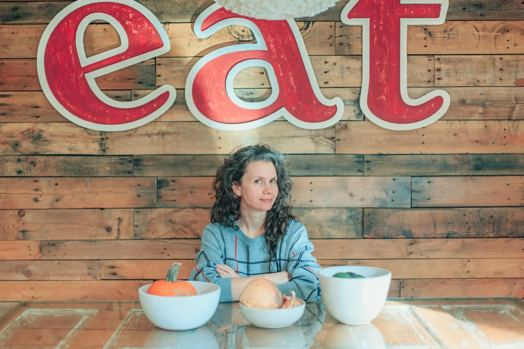 Ranya Dube sitting at a table with the word eat behind her.