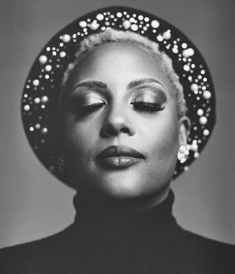 Portrait d'une femme africaine avec un maquillage sophistiqué et un grand collier, vue partielle avec yeux et lèvres.