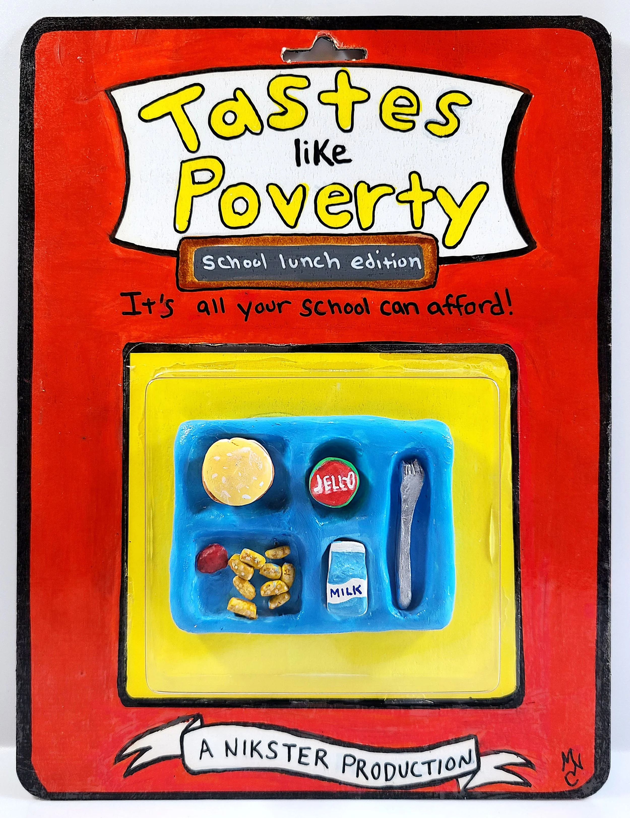 A handmade toy of a school lunch tray and the text "Tastes like Poverty School Lunch Edition - “It’s all your school can afford!”"