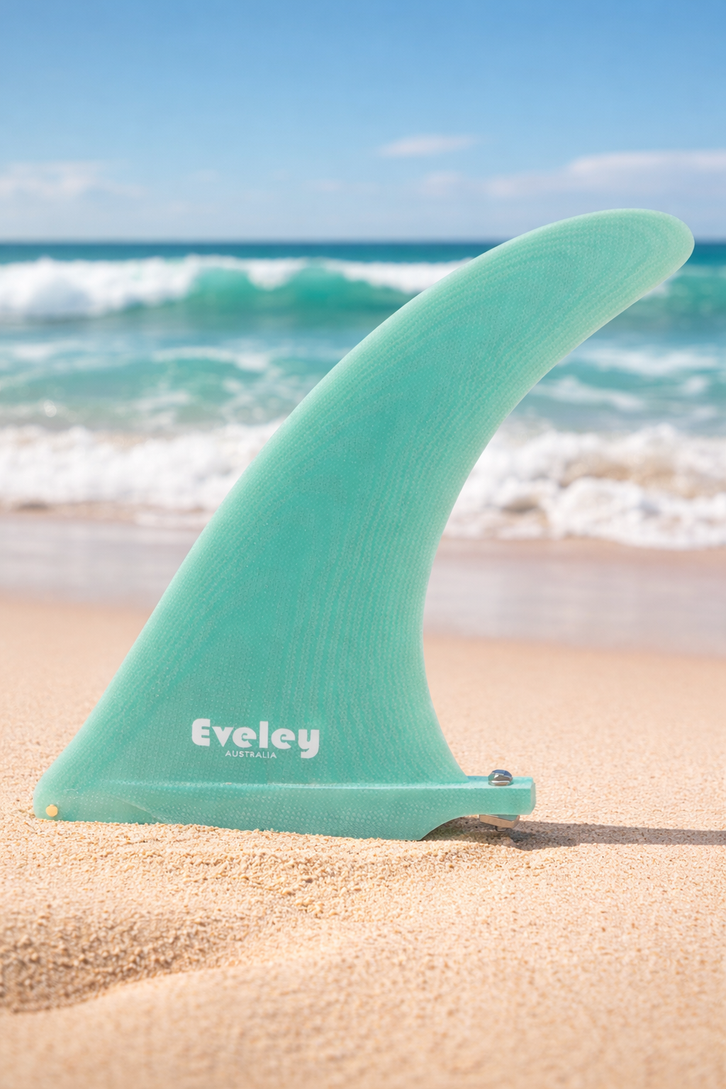 Eveley 8.5 inch International 4A green Pro Glass longboard center fin standing on sandy beach with surf behind.