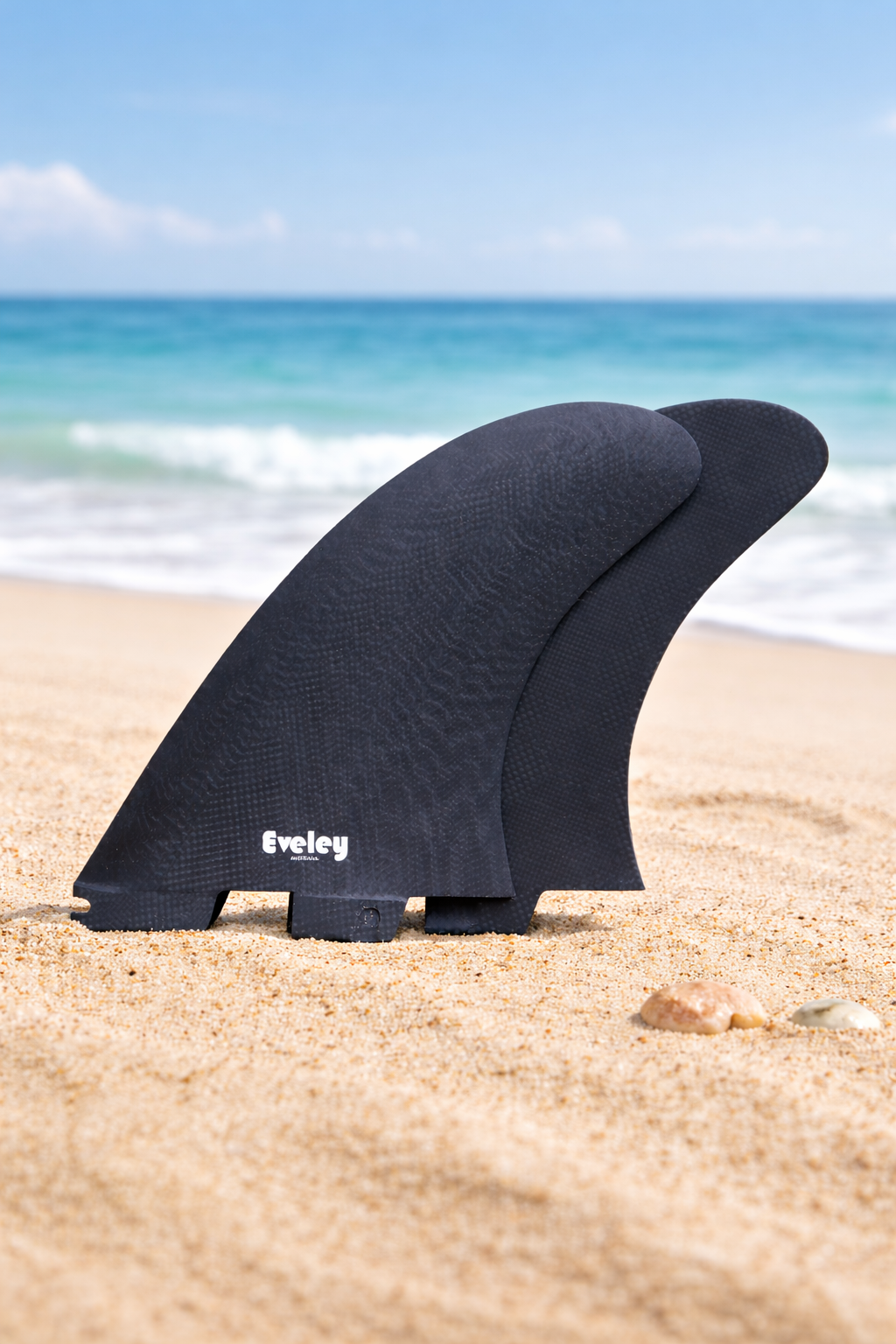 Surfboard fins on sandy beach.png