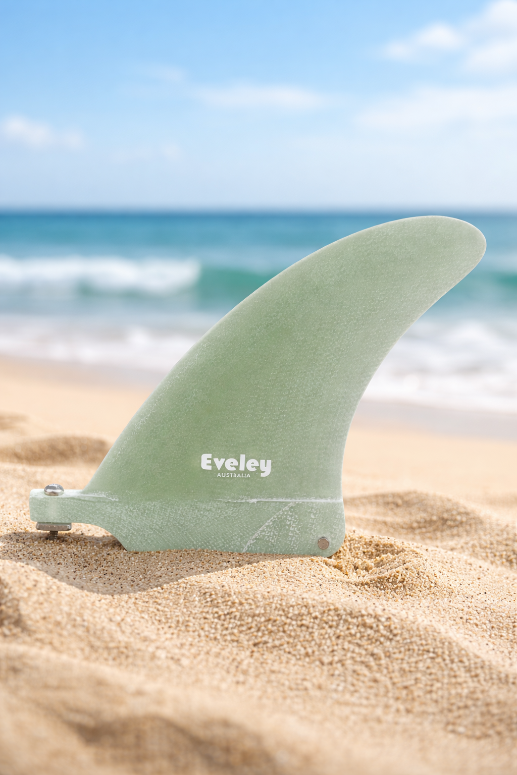 4 inch natural fiberglass surfboard center fin with white Eveley logo on a beach