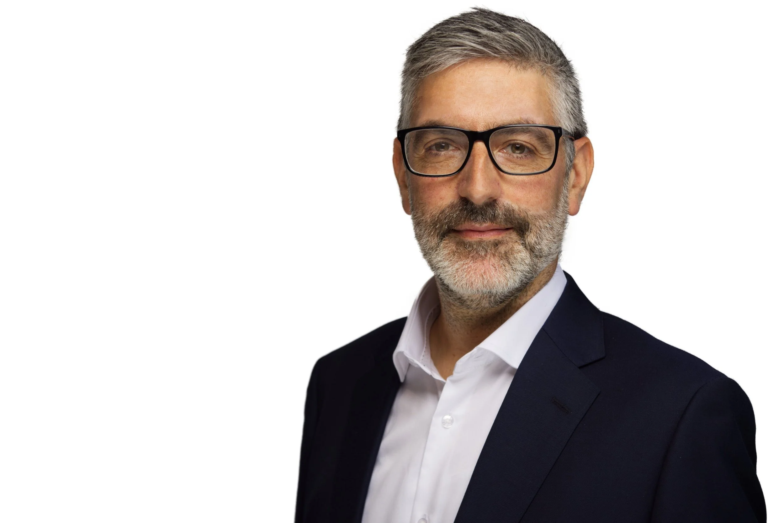 A professional middle-aged man with gray hair, a beard, wearing glasses and a suit, posing against a white background.