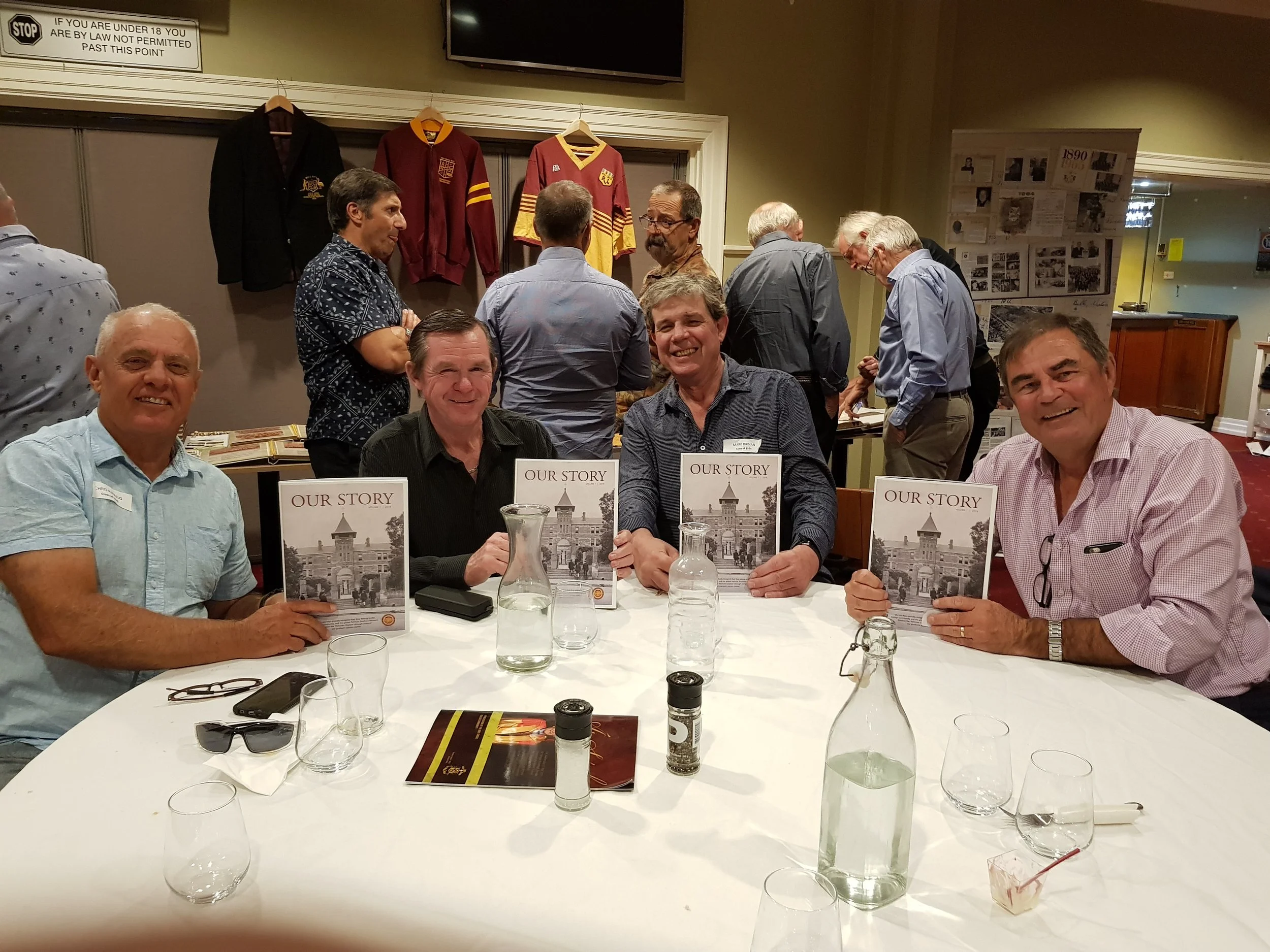 2019 - Maroon & Gold Milestone Reunion at Hunters Hill Club 
(L to R) 1976 Cohorts  Chris Papendara Holy Cross Preparatory (1969-70), David Clifford (1971-74), Mark Drinan (1971-74), Chris Maher (1971-76) all holding their Our Story booklet volume 1