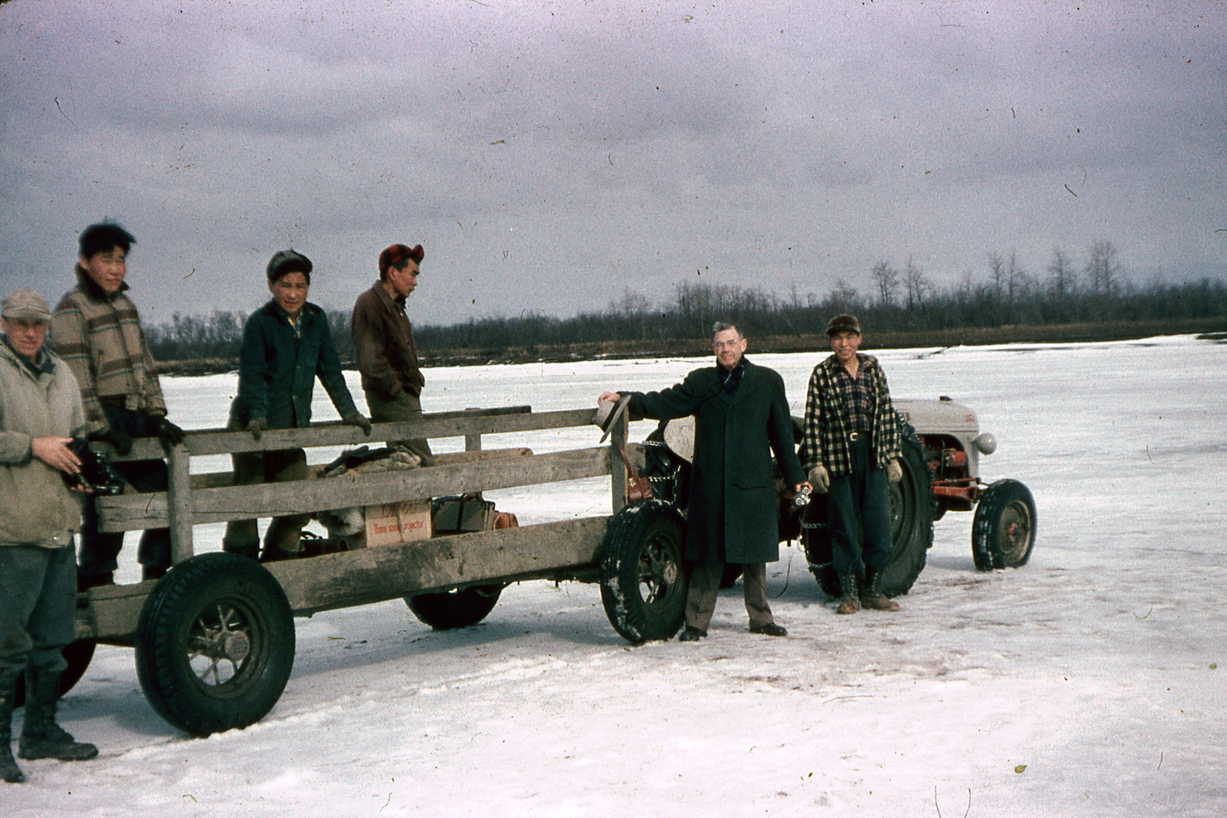 50s - Rev Bayless with C Henkelman tractor travel on the river.jpg
