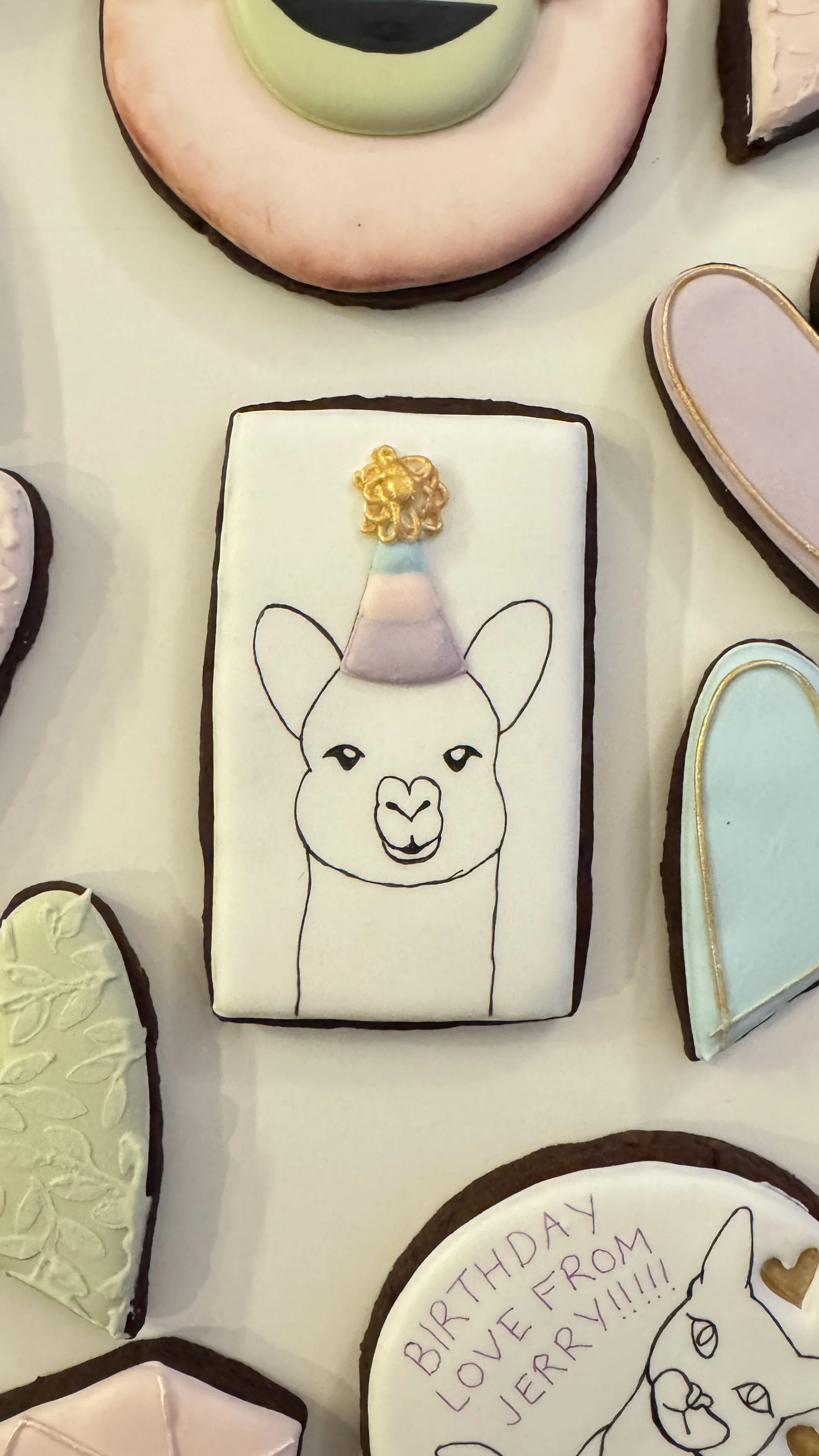Cookie featuring a llama with a birthday hat. 