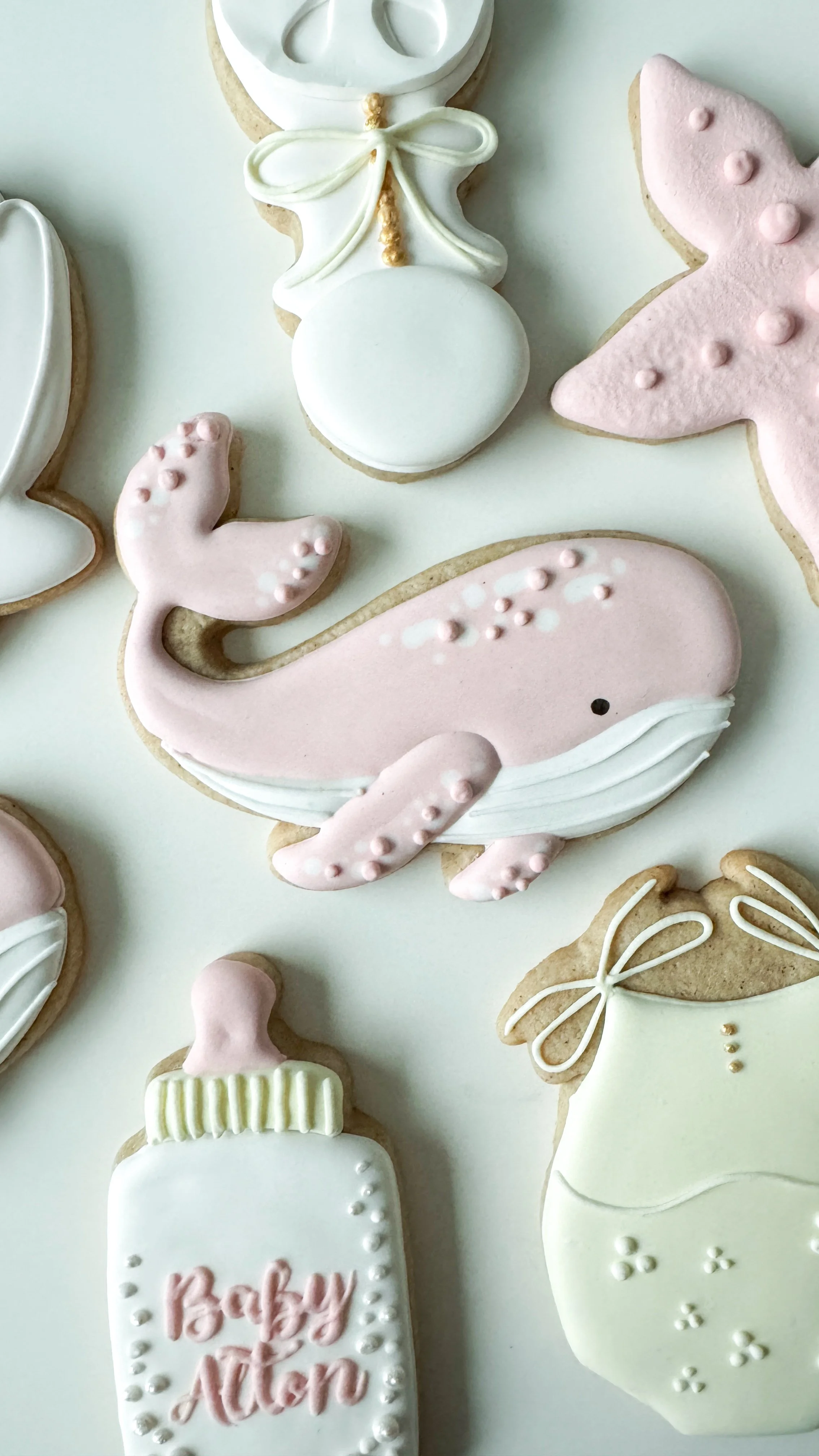 Pink whale cookie as part of a baby girl pastel shower.
