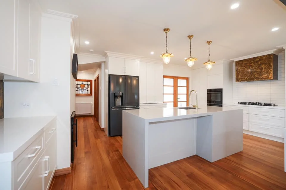 Kitchen renovation with kitchen island and pendant lights. White and brown with timber floors  in Taranaki New Plymouth 