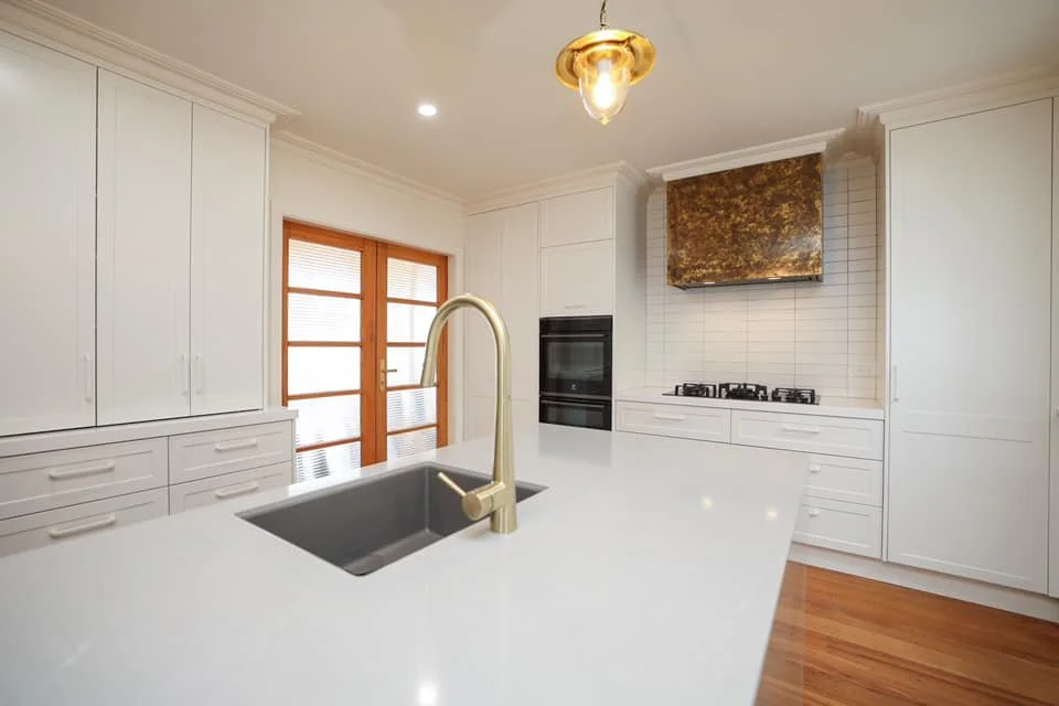 Modern kitchen renovation with gold brass tap ware on kitchen island and timber flooring  in Taranaki New Plymouth 