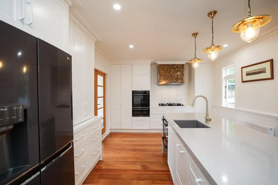 New modern kitchen renovation with timber flooring and white floor to ceiling storage  in Taranaki New Plymouth 