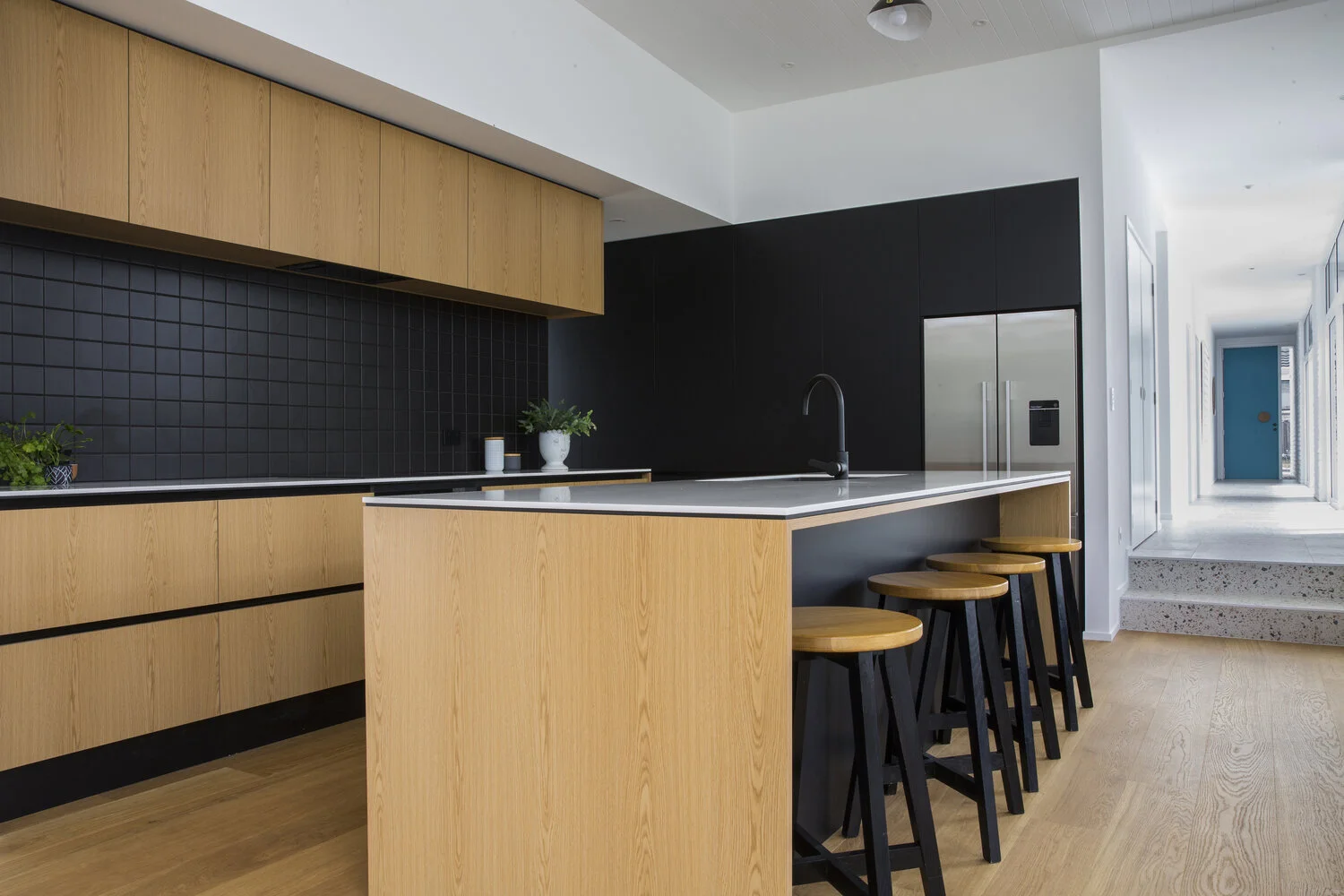 newly renovated kitchen with timber floors and black tile splash backs