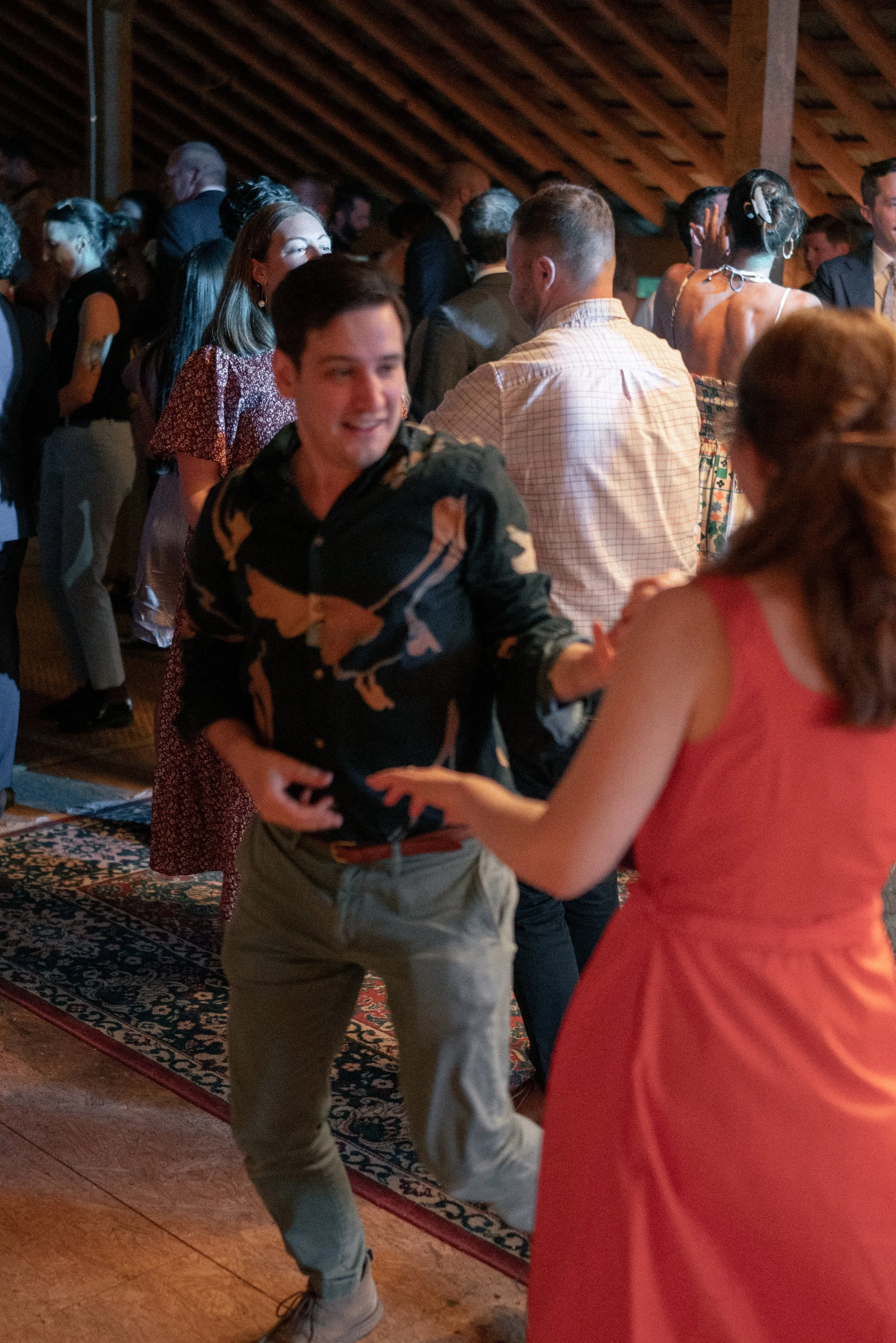 People dancing at a social event in a wooden hall.
