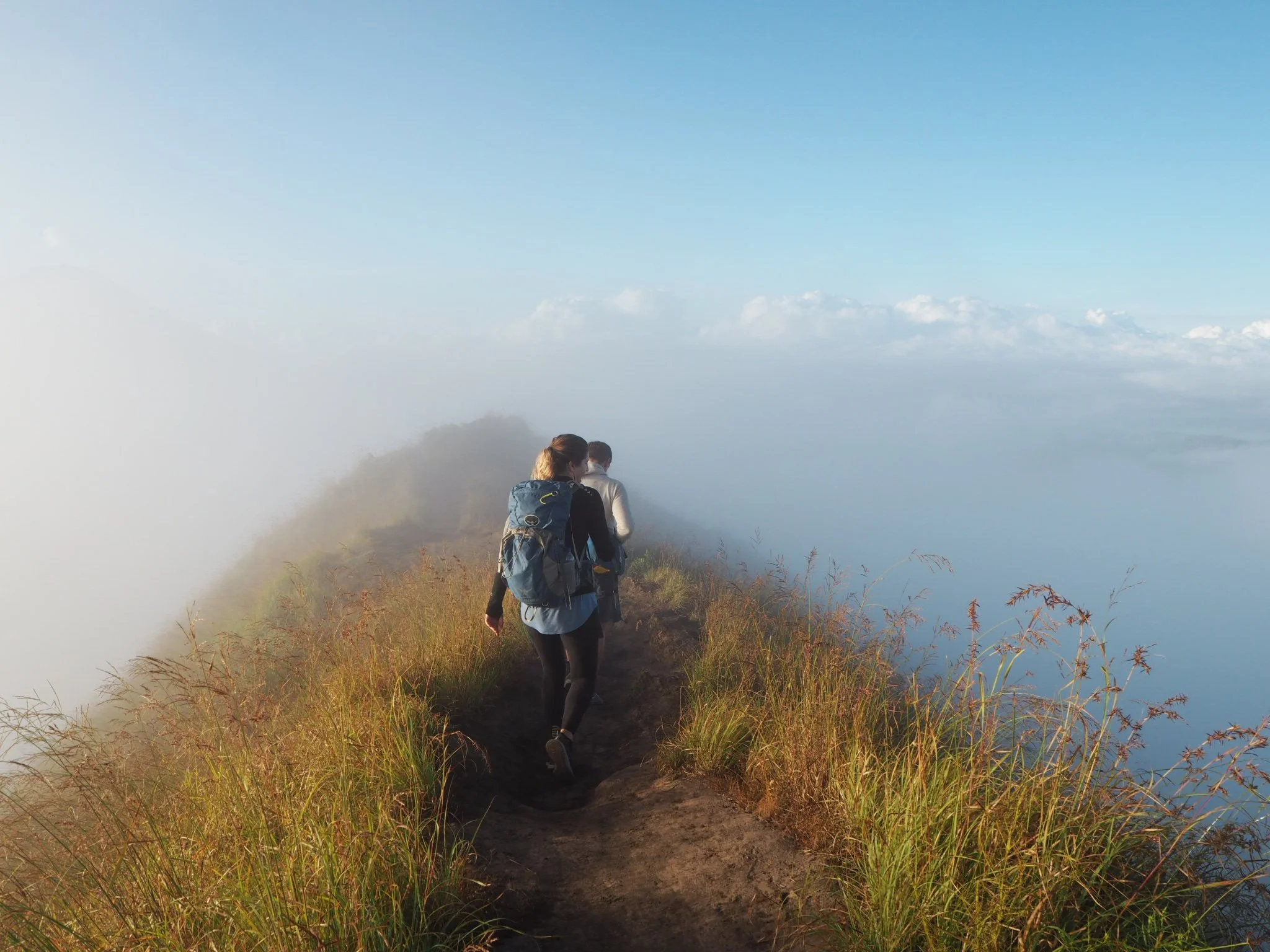 Hikers walking on top of a misty mountain