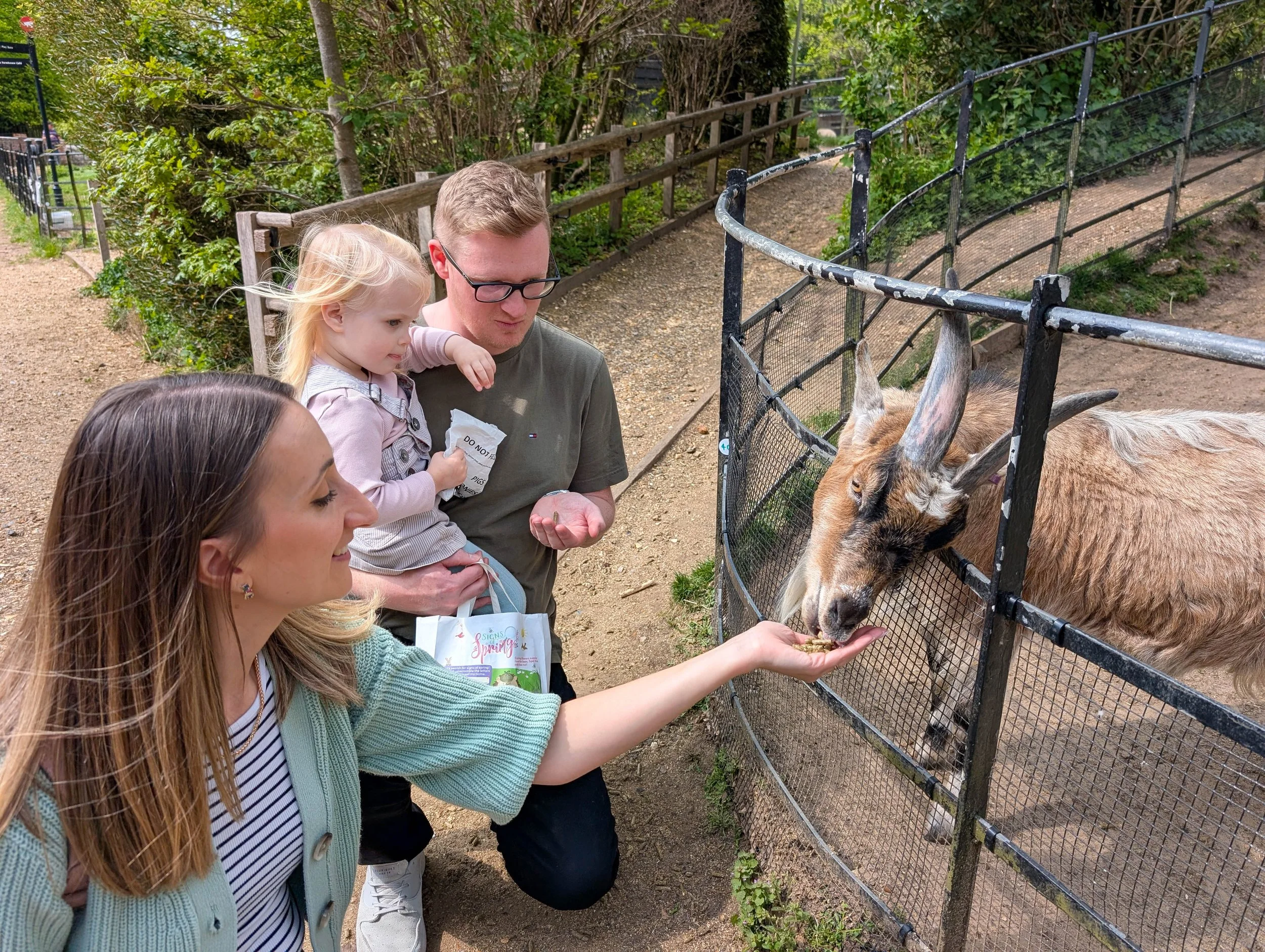 Family at a farm feeding a goat