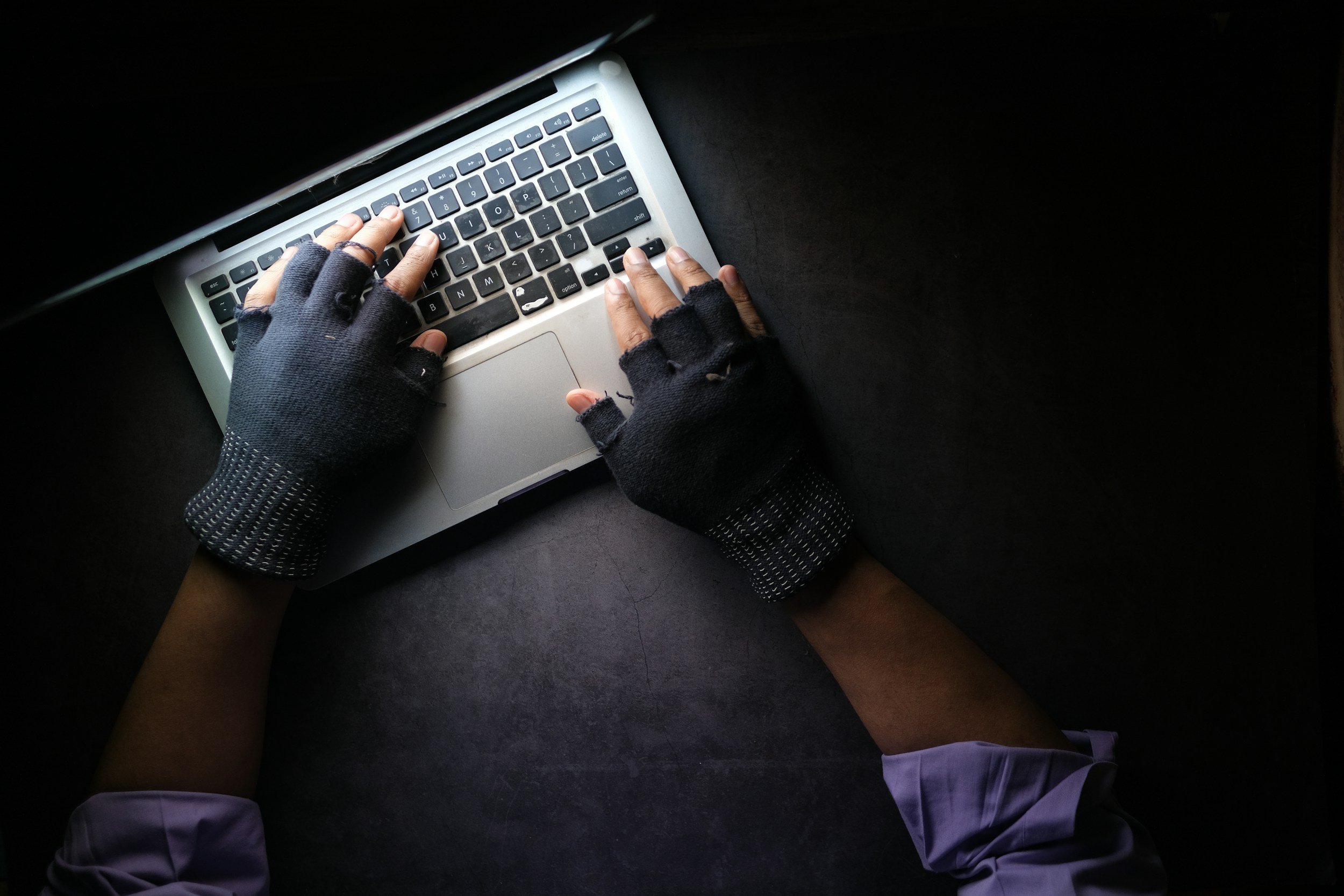 To hender med hansker som skriver på tastatur