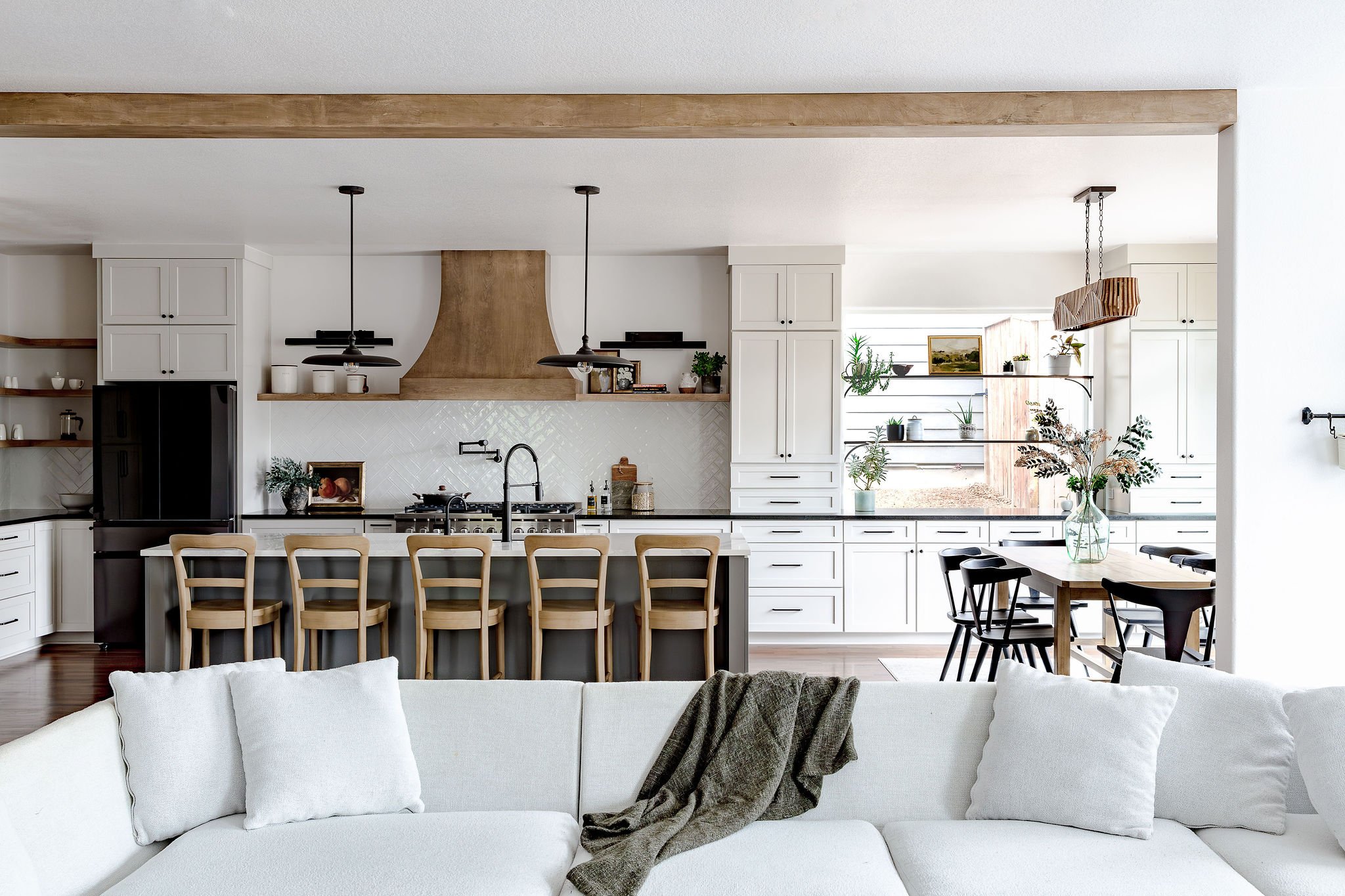 Custom kitchen remodel blending classic and modern design with wood range hood, oversized island seating, and thoughtful storage solutions
