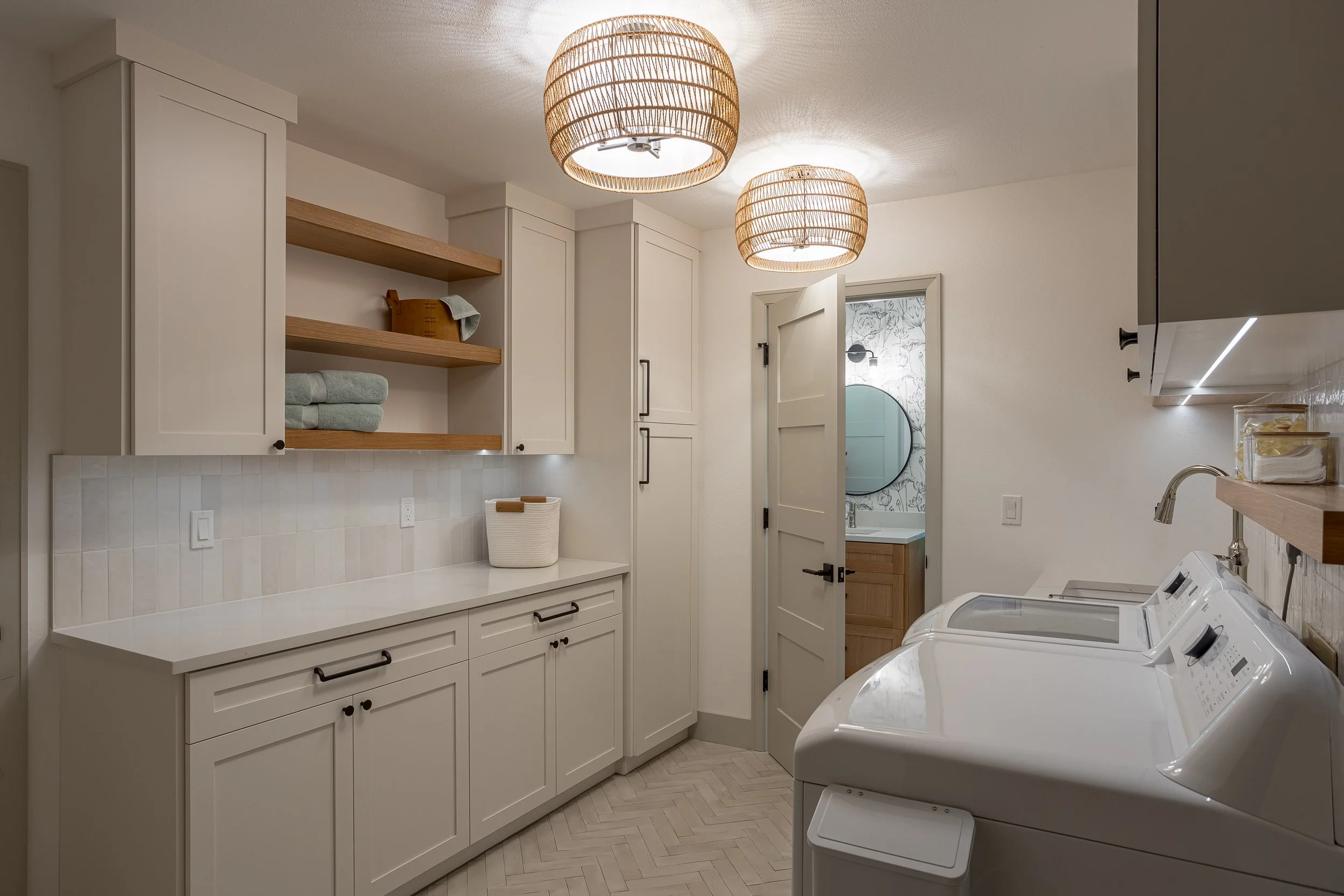 Clean Laundry room, Laundry Room Remodel, Warm white cabinets, Laundry Storage, white bedrosians cloe backsplash, white oak shelves, top knobs matte black hardware