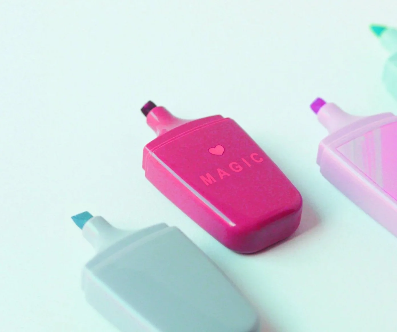 Pink highlighter pen on a turquoise background