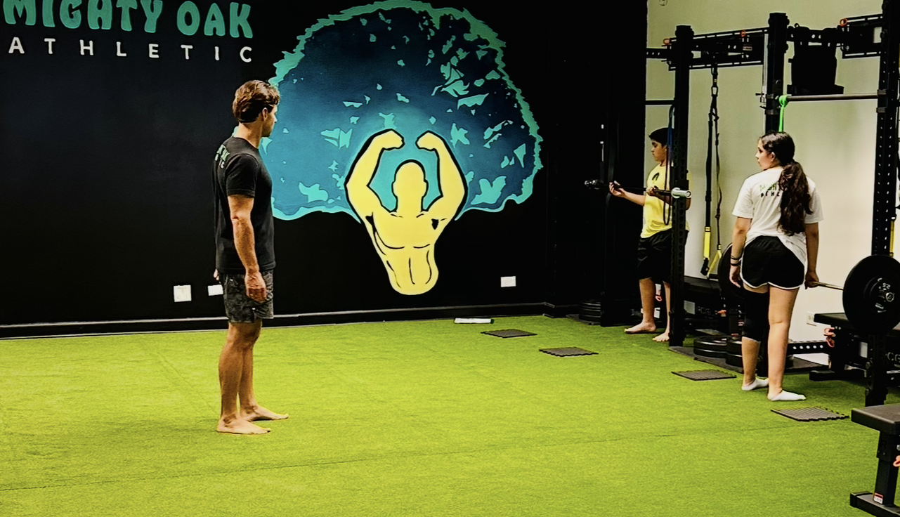 Two middle school kids training at the Mighty Oak Athletic Rogue racks — CSCS-coached youth strength and agility in DuPage County