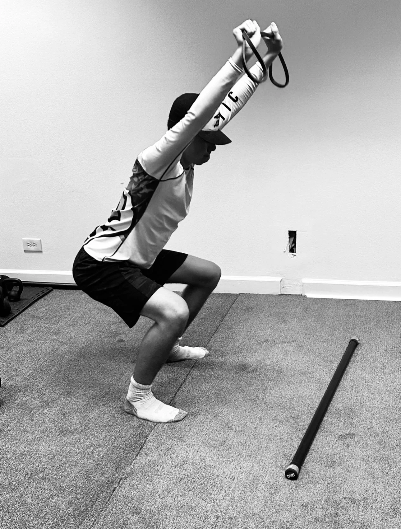 High school boy performing a functional movement screen at Mighty Oak Athletic — mobility and agility assessment during a free training session in Westmont, IL