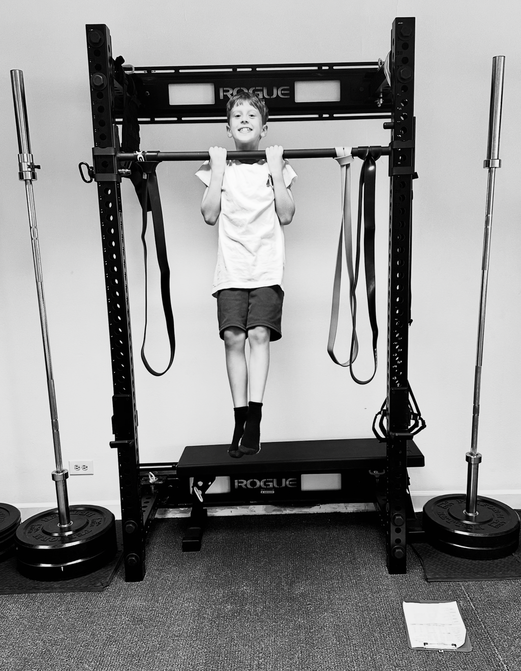 Happy young boy performing a chin-up at Mighty Oak Athletic — bodyweight strength training for kids in Westmont and DuPage County