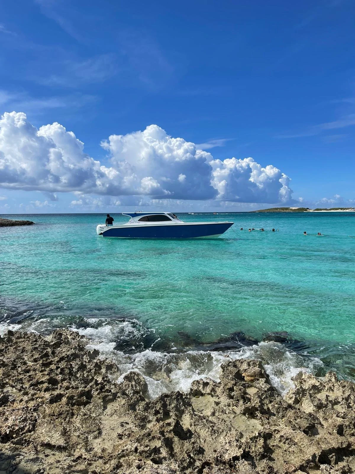 View of GoodLiving Charters boat anchored in crystal clear water at Little Bay, Anguilla.