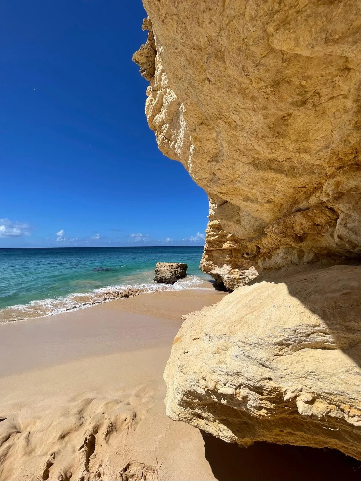 Cliffside view of Little Bay beach in Anguilla with turquoise water and golden sand