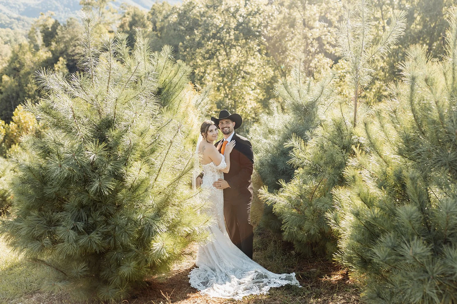 Mountain Mist Farms' forest is displayed in this portrait with the couple looking at the camera in the center of the photo.