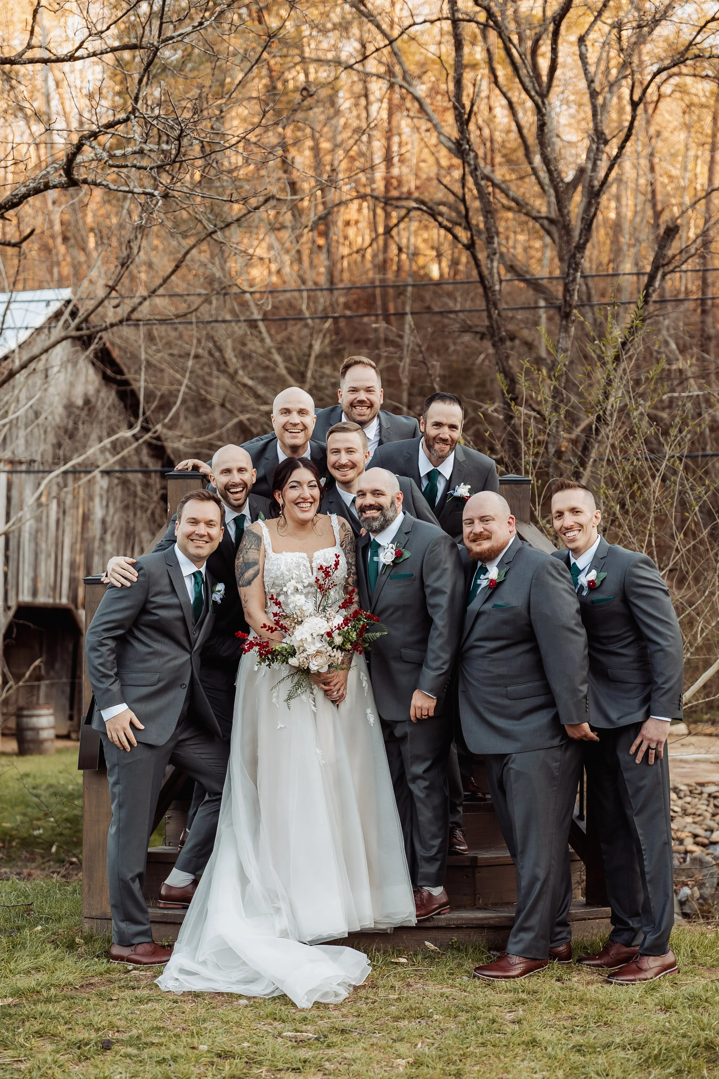 A bride is posing with her groomsmen wearing grey suits.