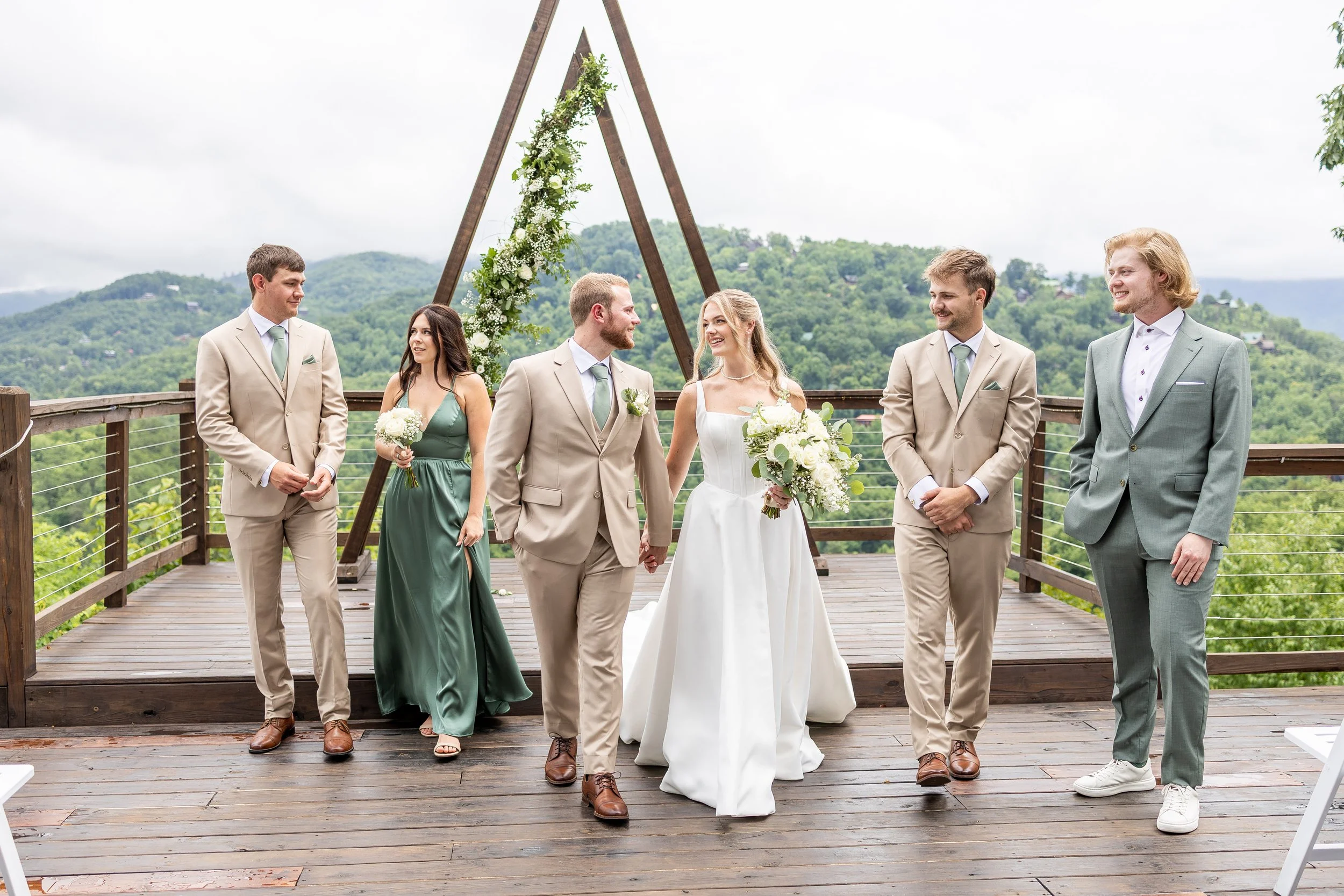 A bridal party walks toward the camera at the ceremony location.