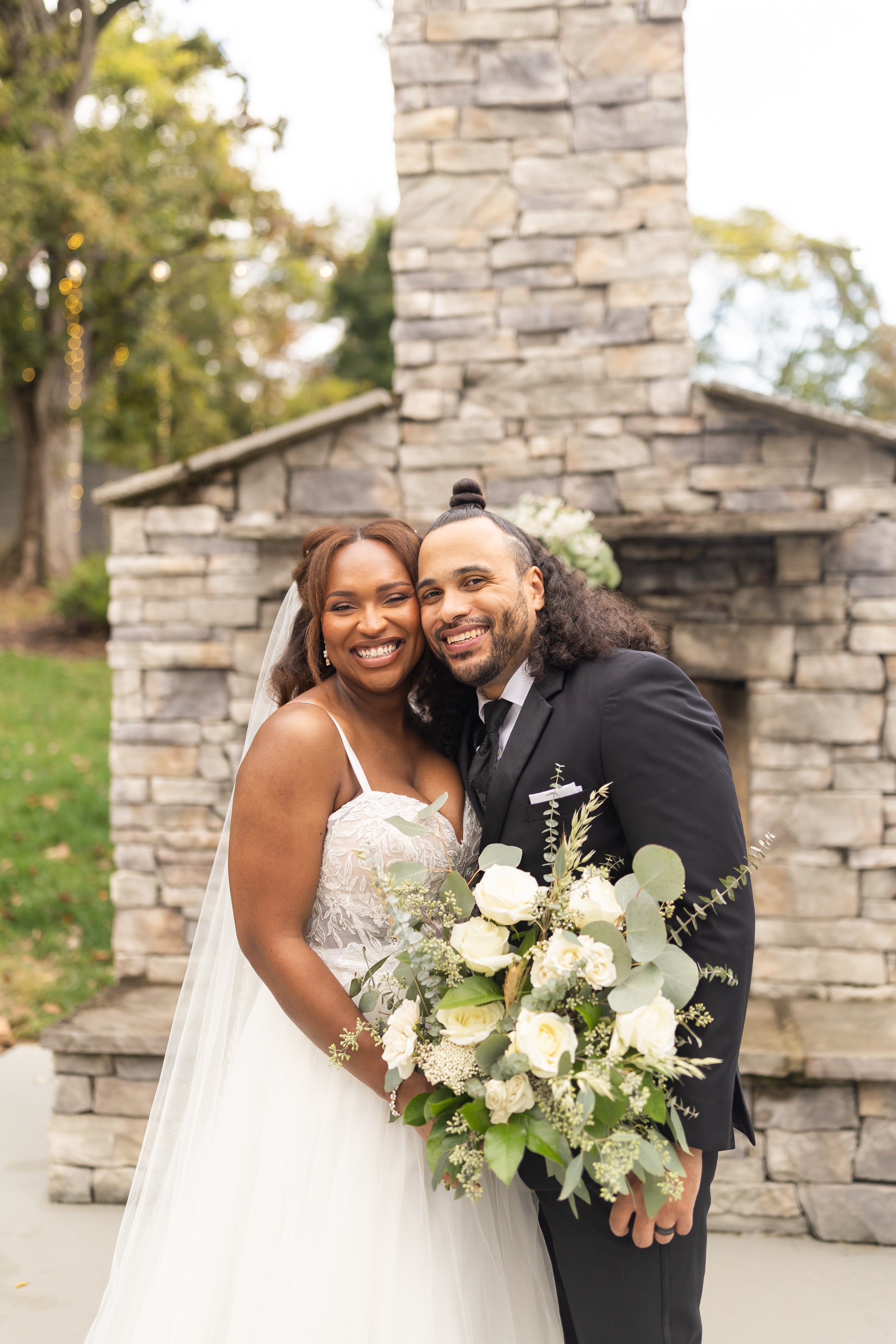 A couple holds close together in front of the fireplace.