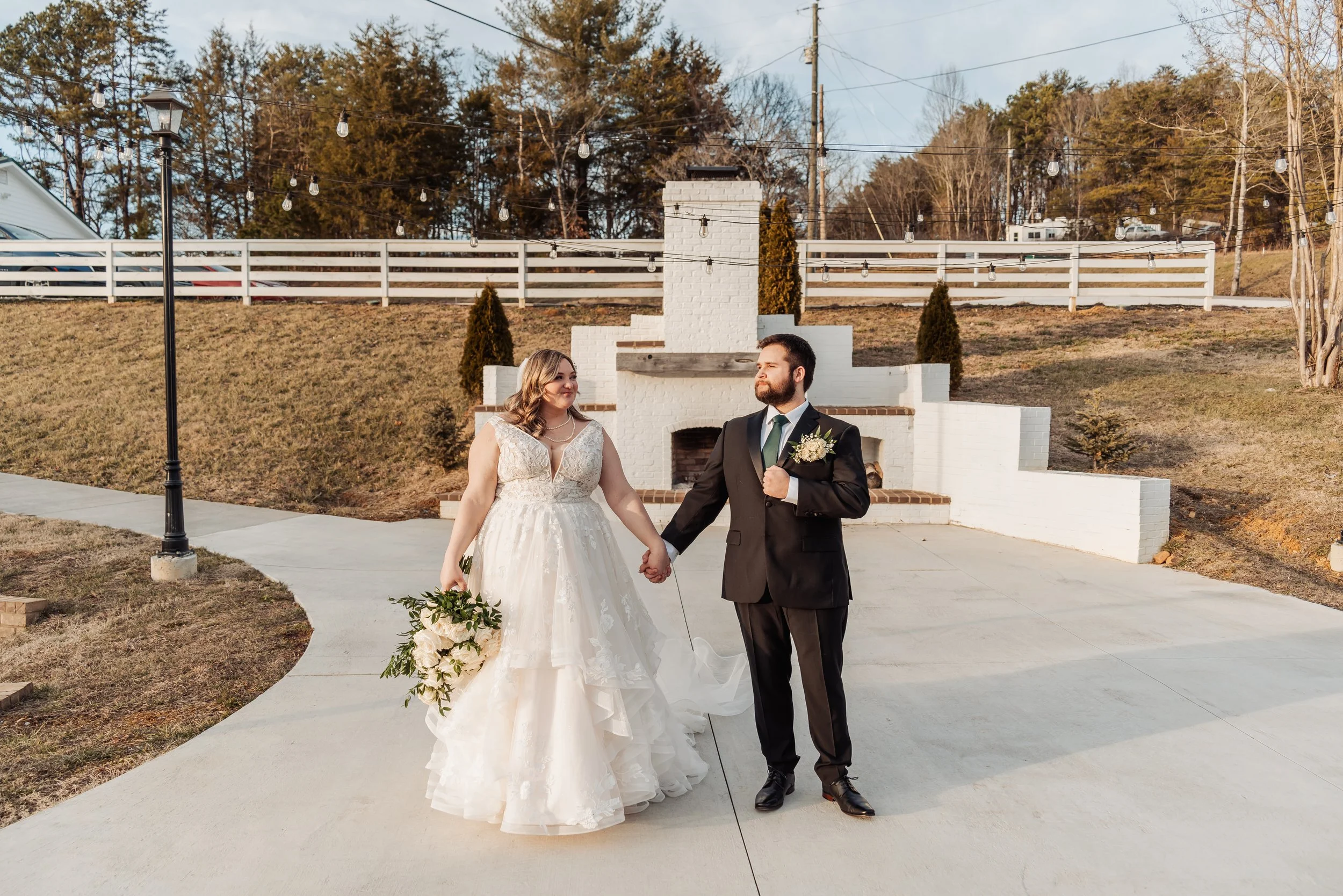 The couple poses by the Wildflower Farm sign.
