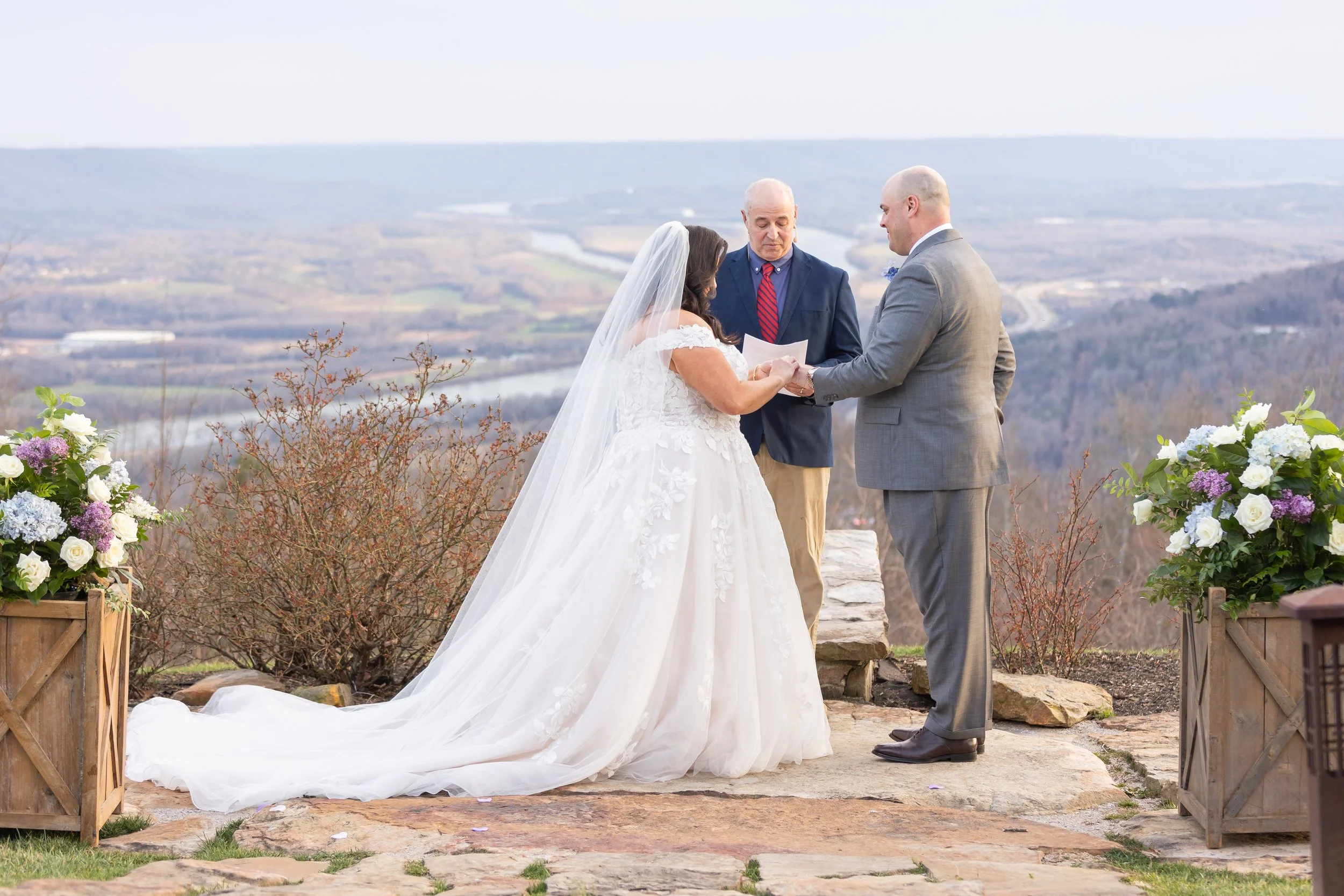 A couple stands in the sunset at Pat's Summit reading vows with mountain views.