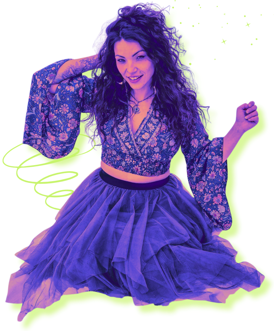 A woman with curly hair, wearing a floral crop top and a layered tulle skirt, smiling and posing with one hand behind her head and the other flexed.