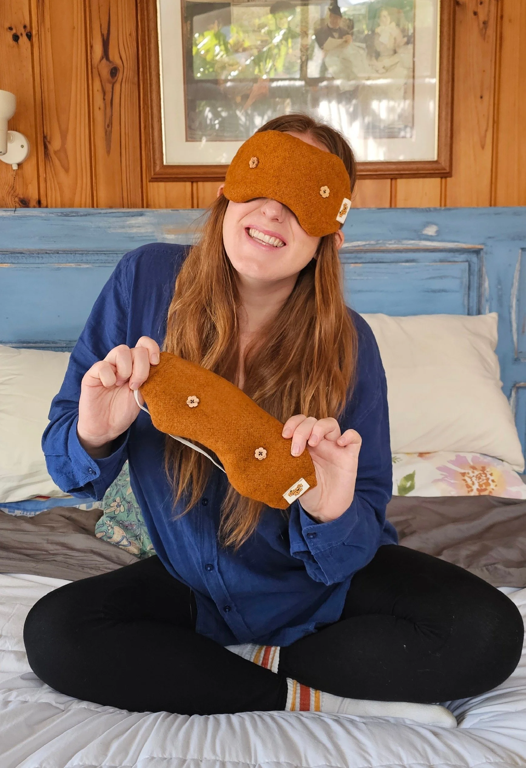 Kate Hall / Ethically Kate wearing the limited-edition Orchard Orange weighted eye mask while holding a second matching eye mask from the Ethically Kate × Do Not Disturb collaboration, handmade in New Zealand.