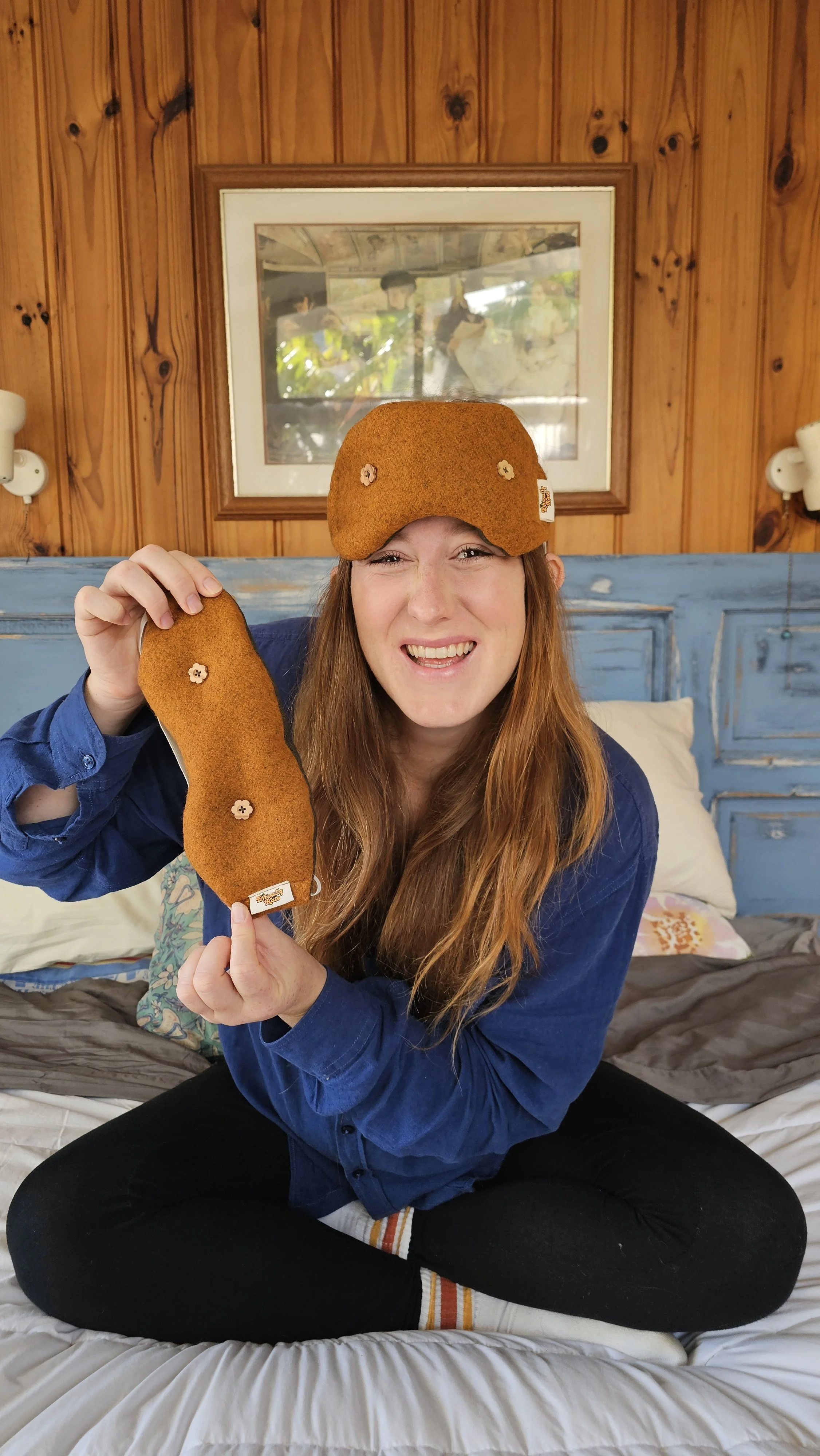 Kate Hall wearing and holding the limited-edition Orchard Orange weighted eye mask from the Ethically Kate × Do Not Disturb collaboration, handmade in New Zealand to support better sleep, naps and rest.